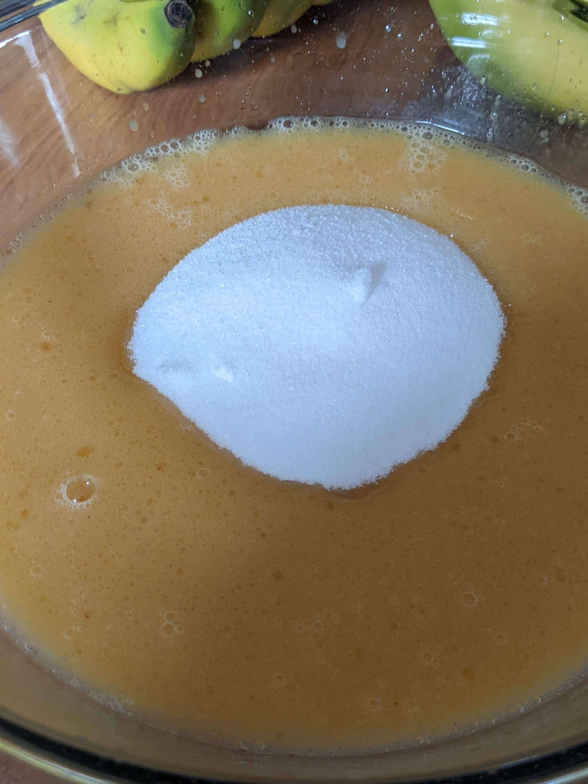 sugar in orange liquid in a clear bowl