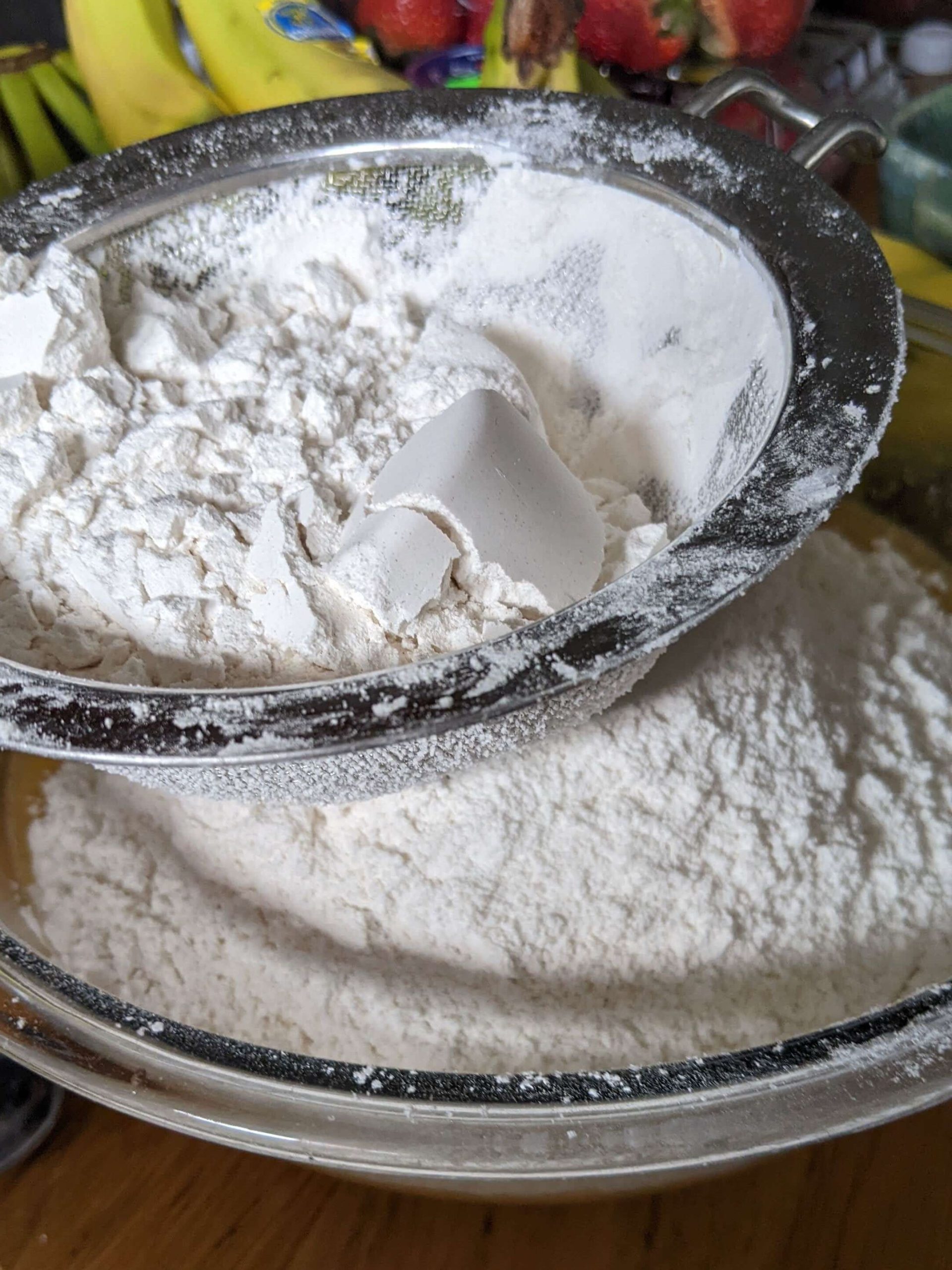 flour being sifted into a bowl