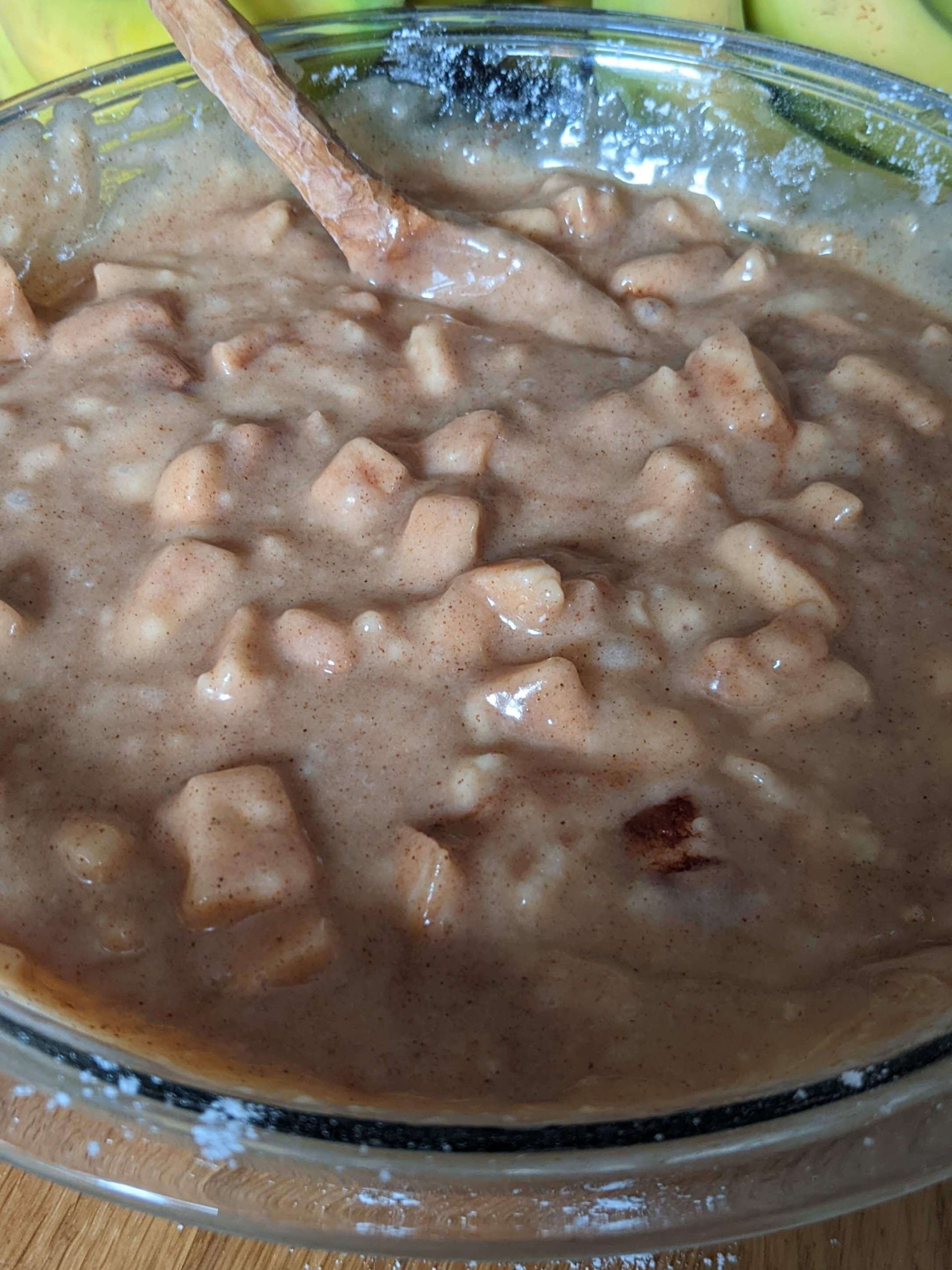 apples incorporated into batter with a wooden spoon