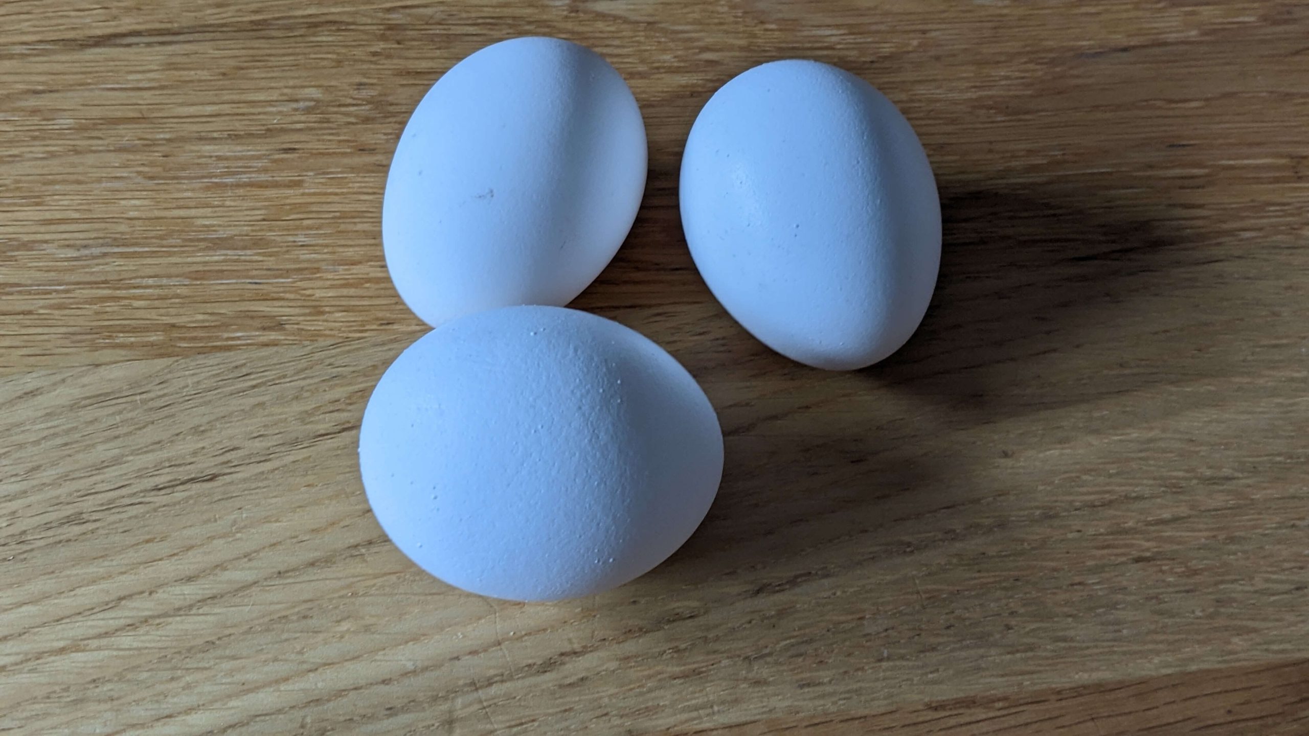 3 eggs on a wooden counter