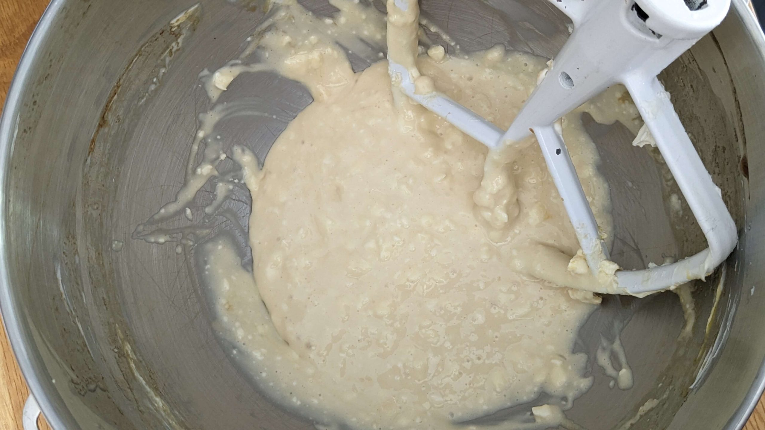 cream mixture in a silver kitchen aid mixer bowl with the beater attachment