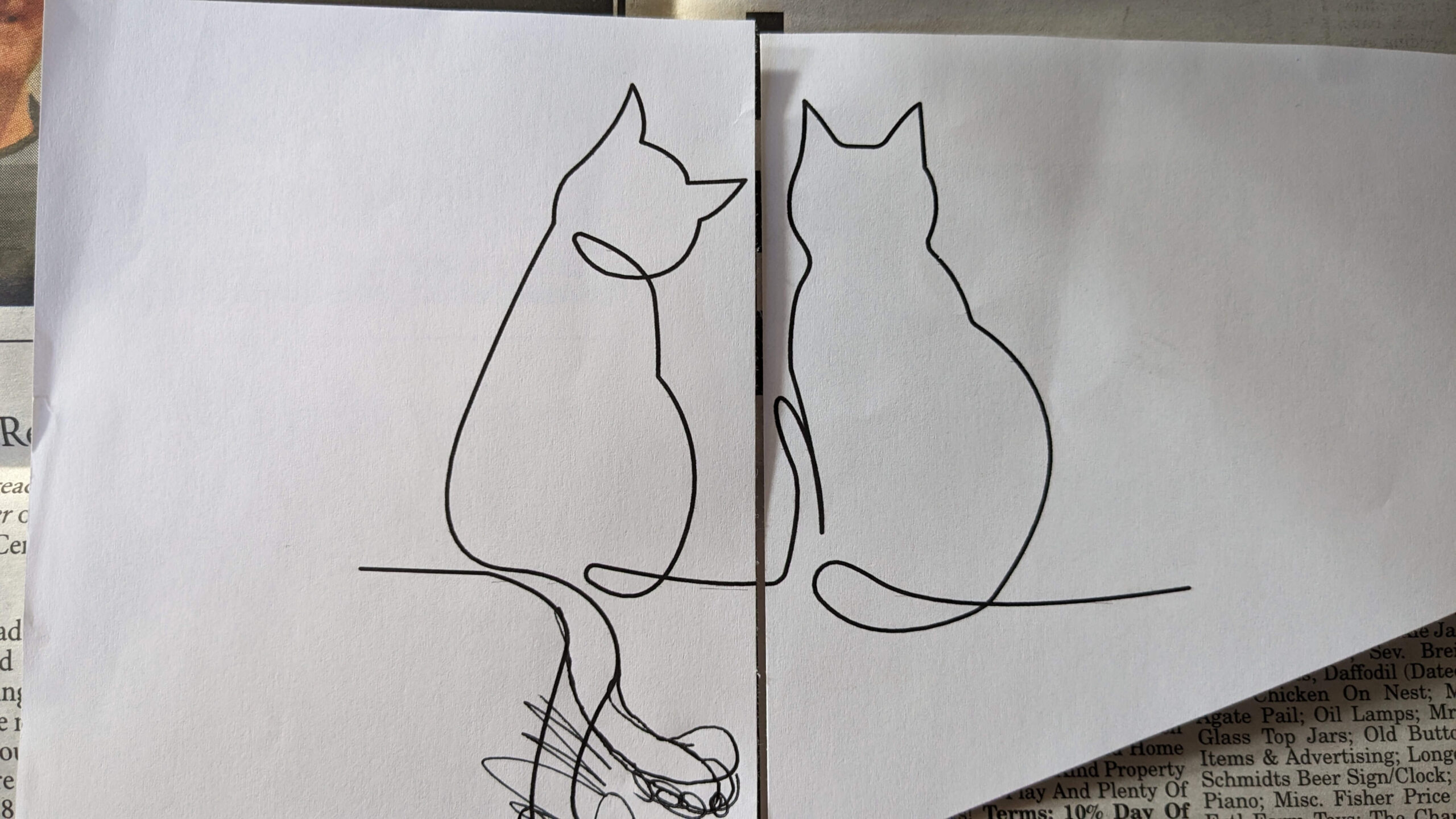paper with a line drawing of two cats