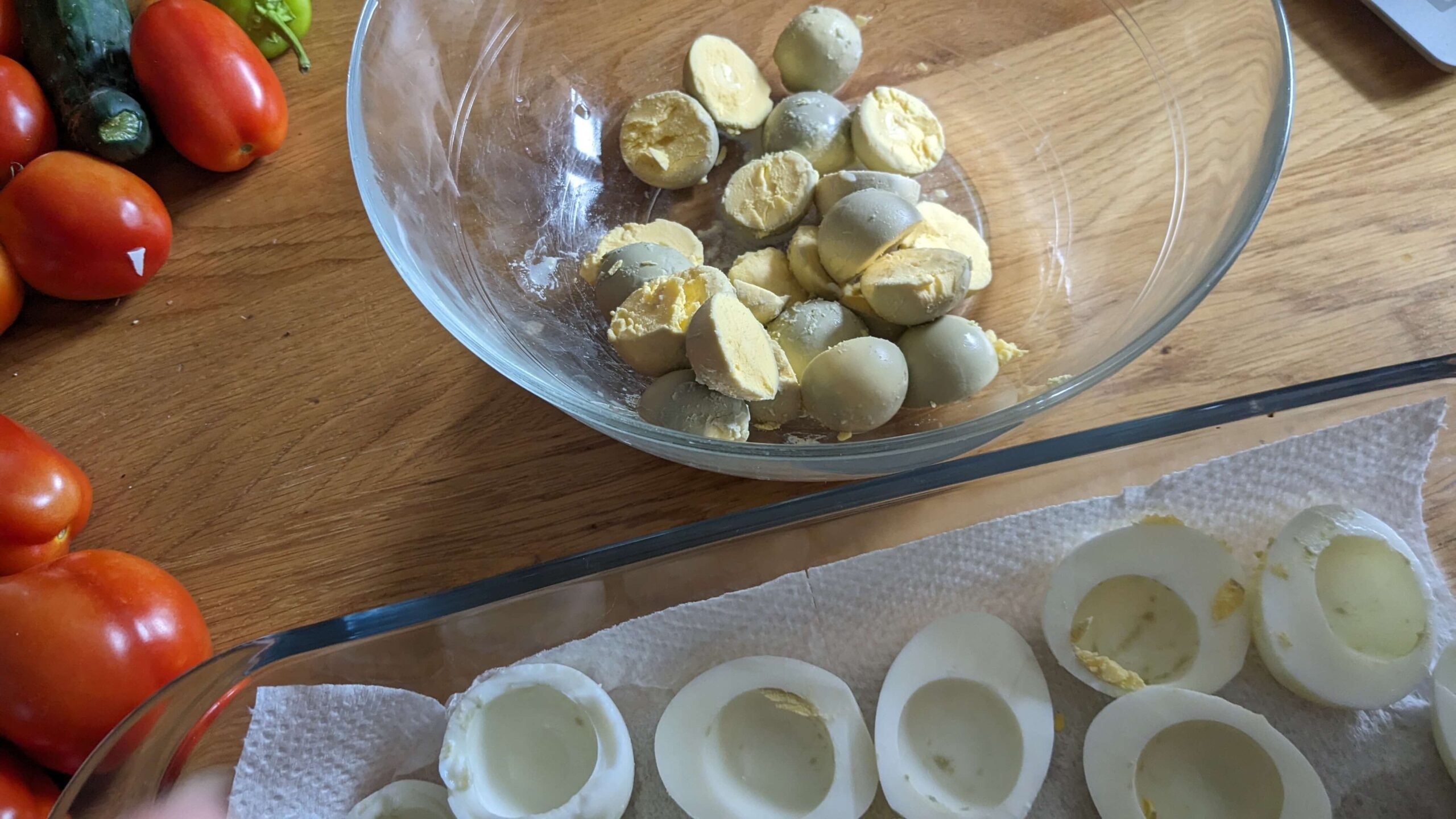 a bowl of hard boiled egg yolks next to a tray of hard boiled egg whites