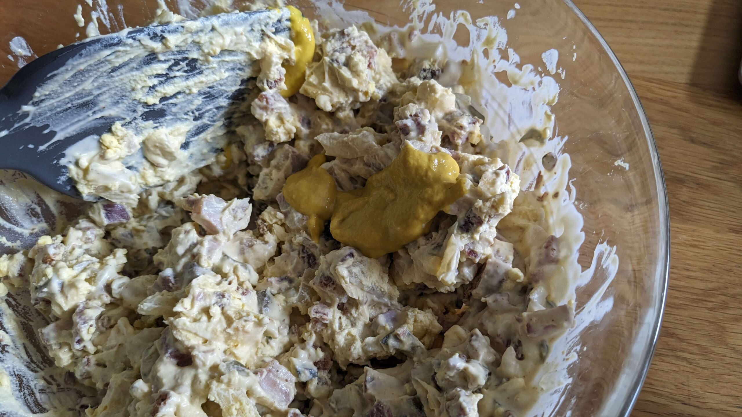a glass bowl of deviled egg mixture and mustard
