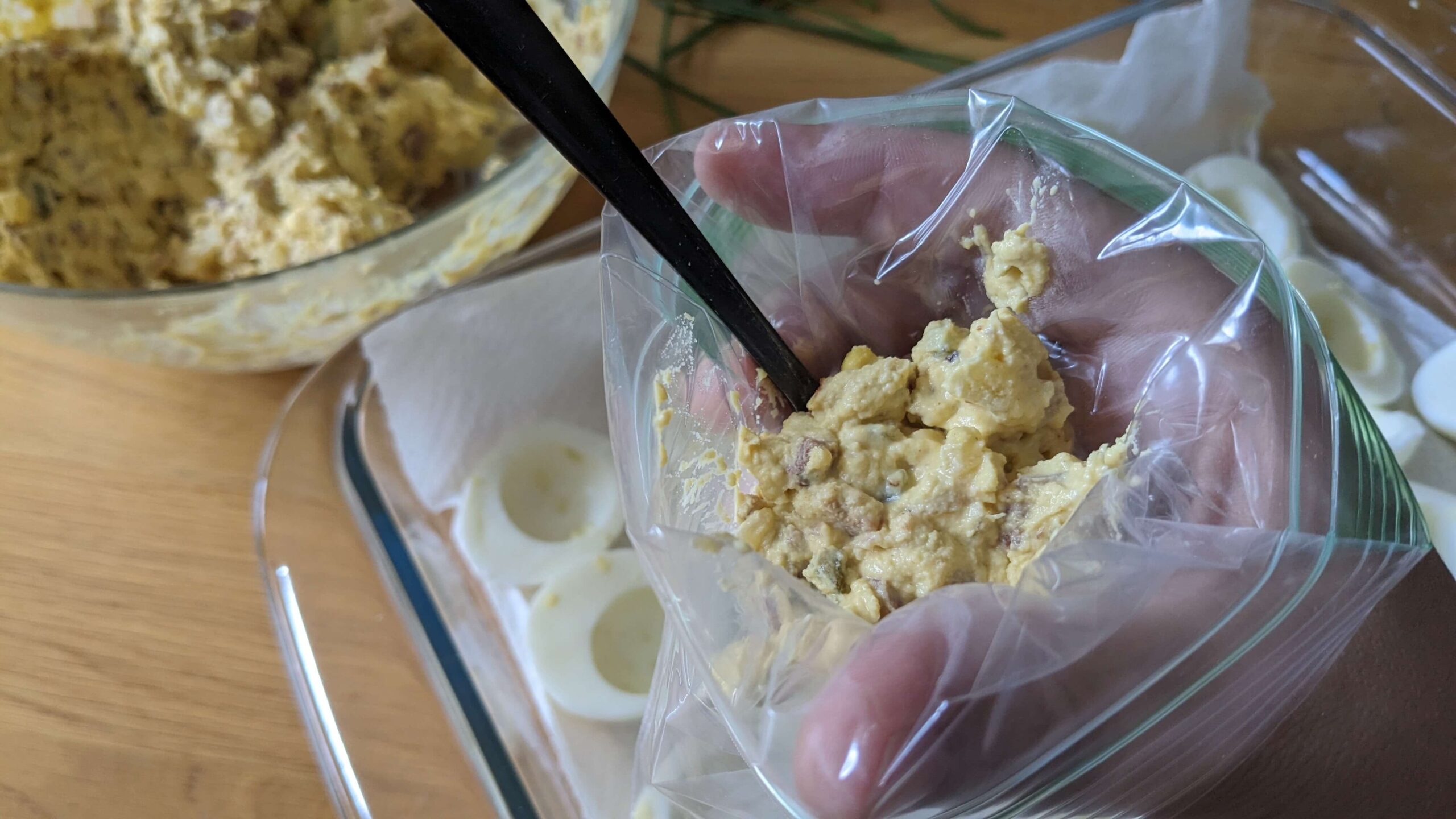 woman holding a plastic bag filled with deviled egg filling moxture