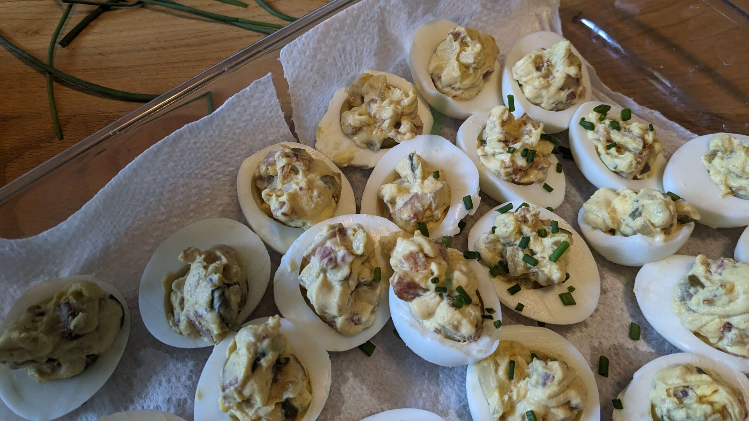 a tray of deviled eggs topped with chives