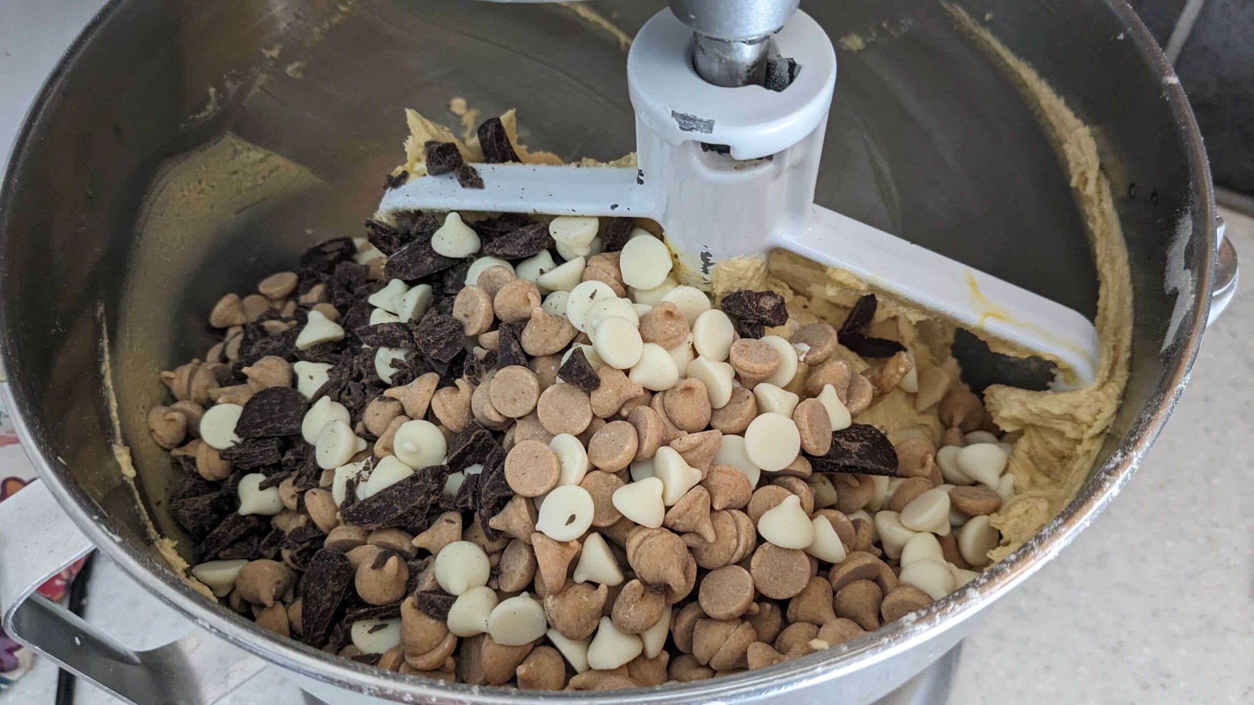 chocolate chips, peanut butter chips, and white chocolate chips in a kitchen aid mixer