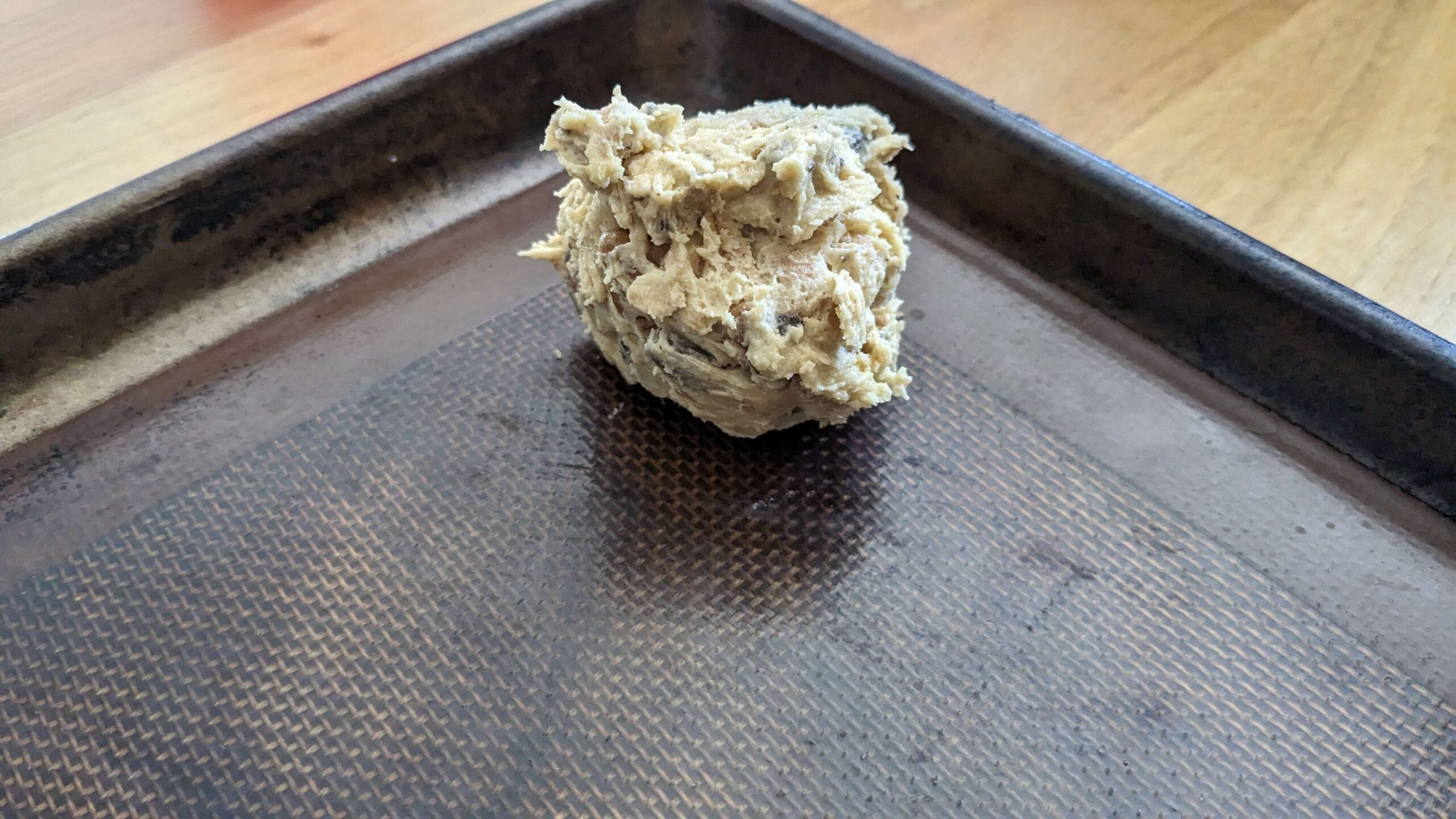 scoop of cookie dough on a silpat on a baking tray