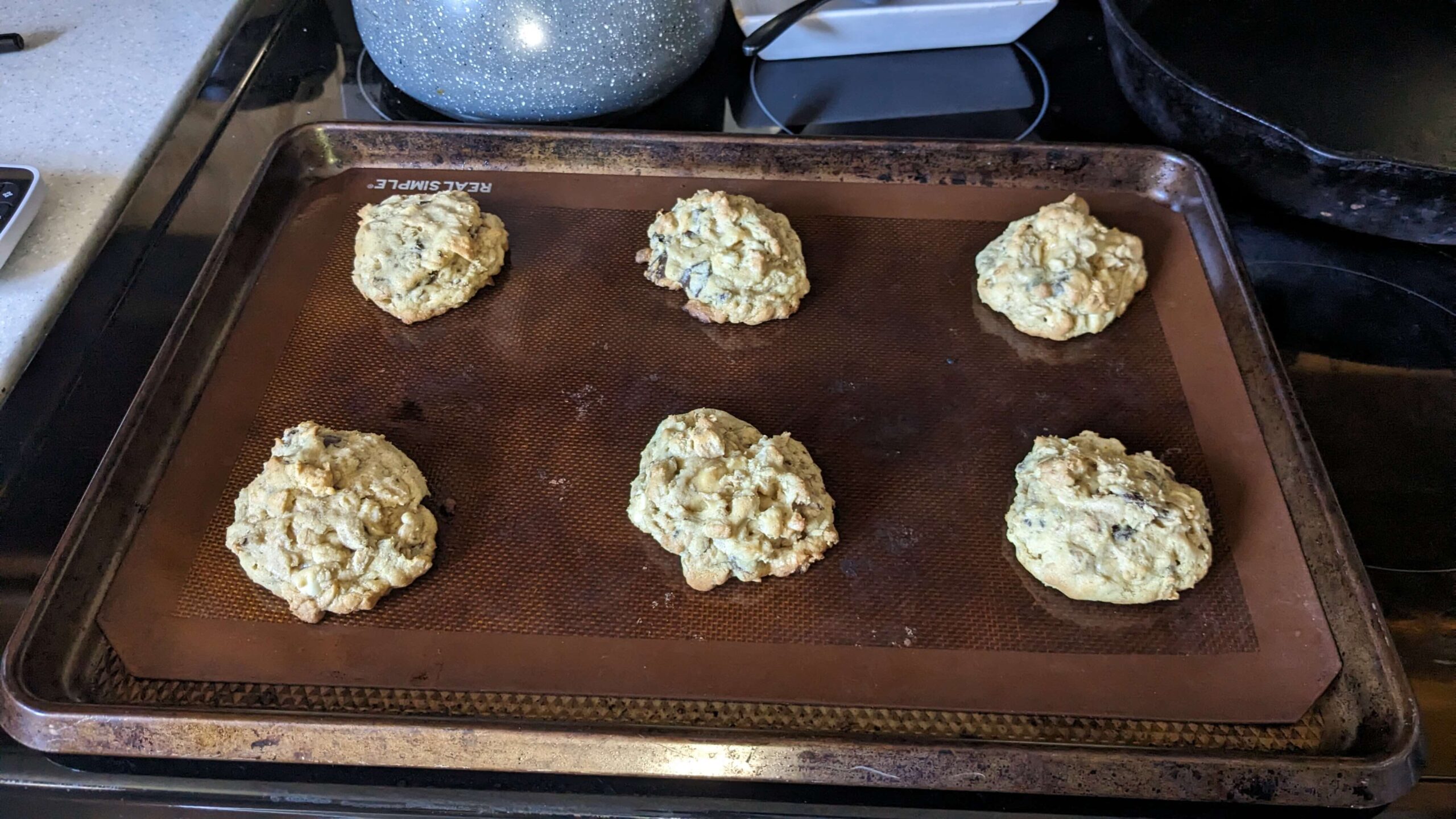 six cooked quarter cup cookies on a cookie sheet