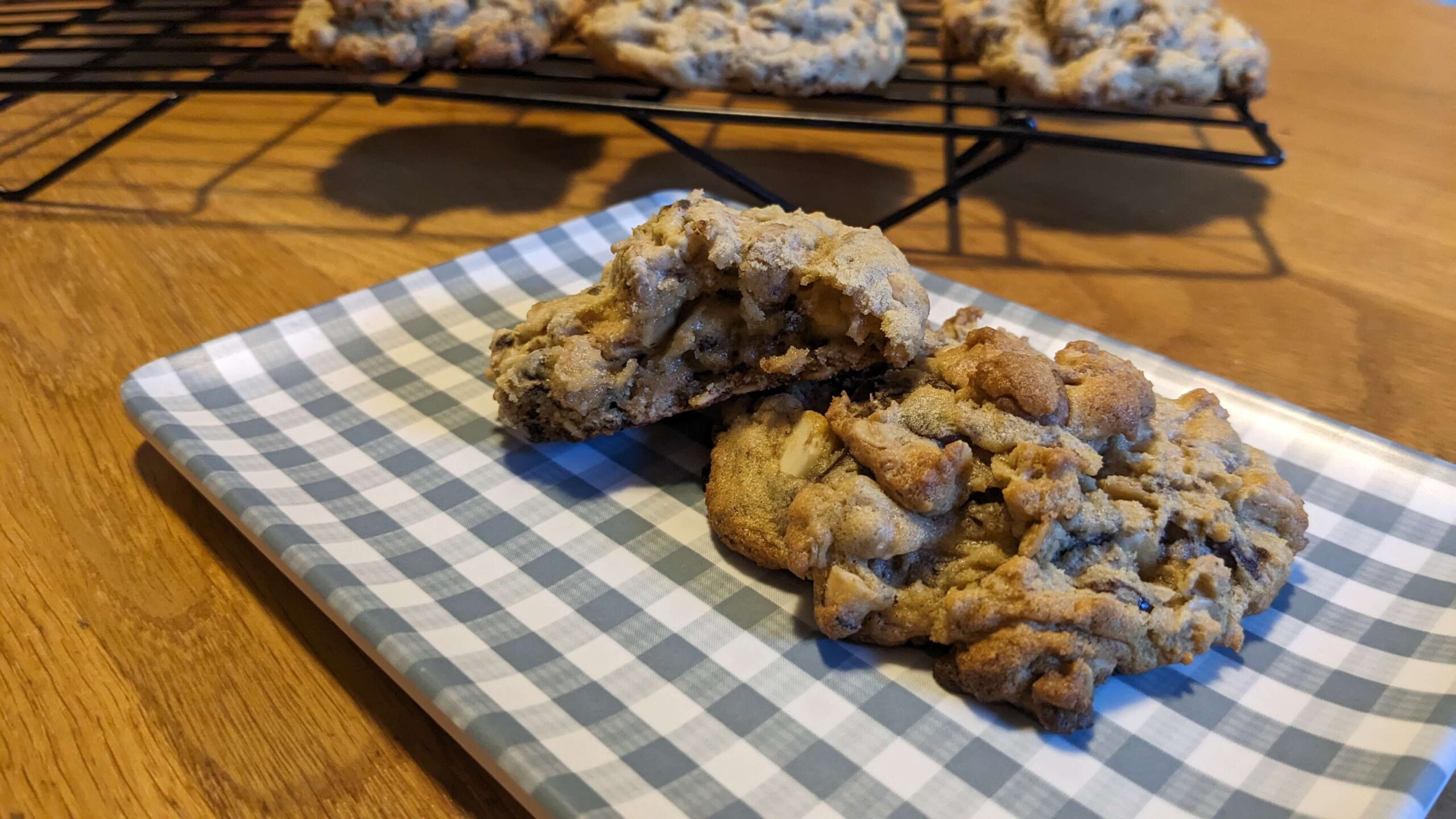 two cookies on a blue checkered rectangular plate, one with a bite taken out. 