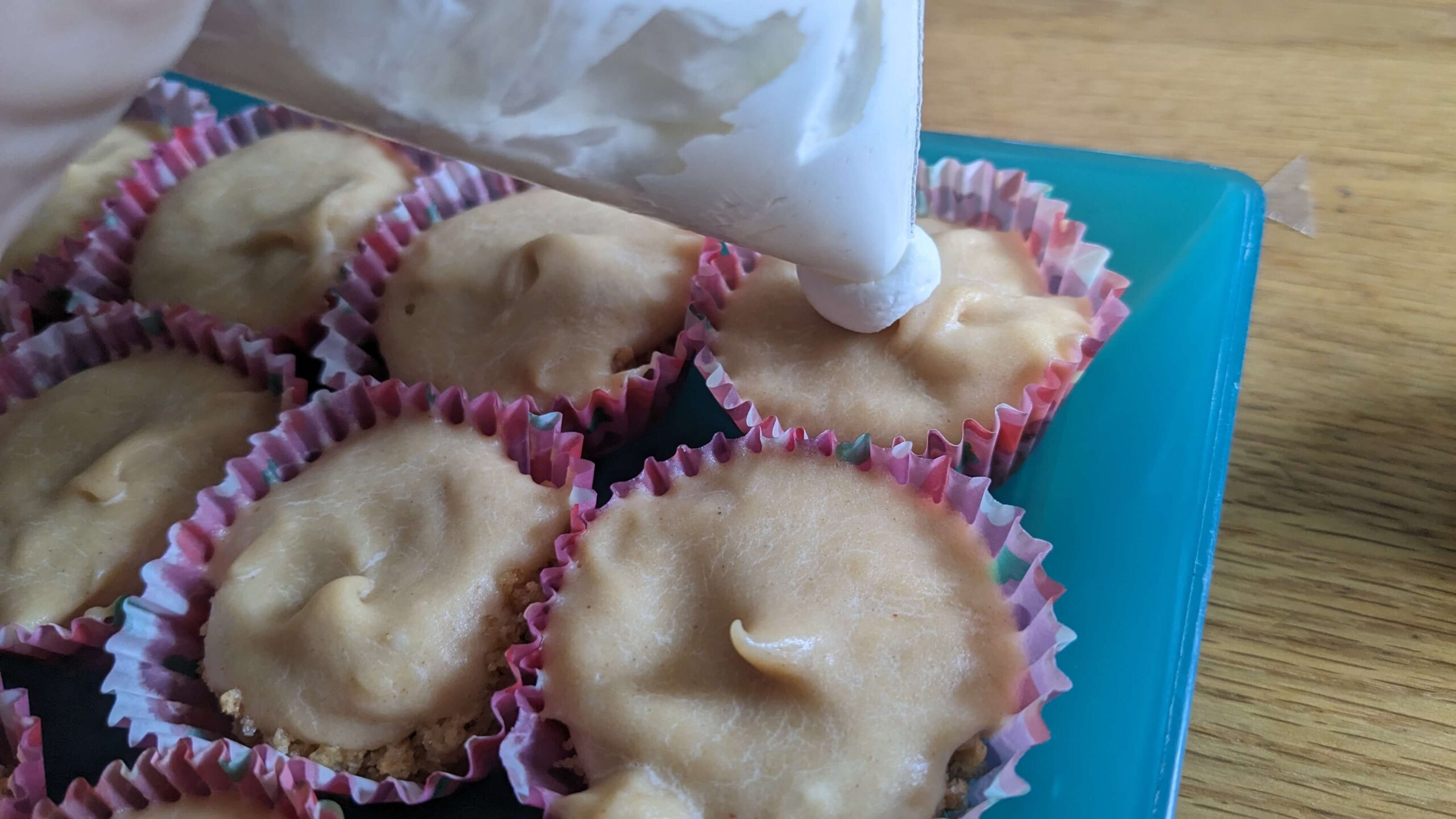 whipped cream being piped onto mini peanut butter cheesecake bite