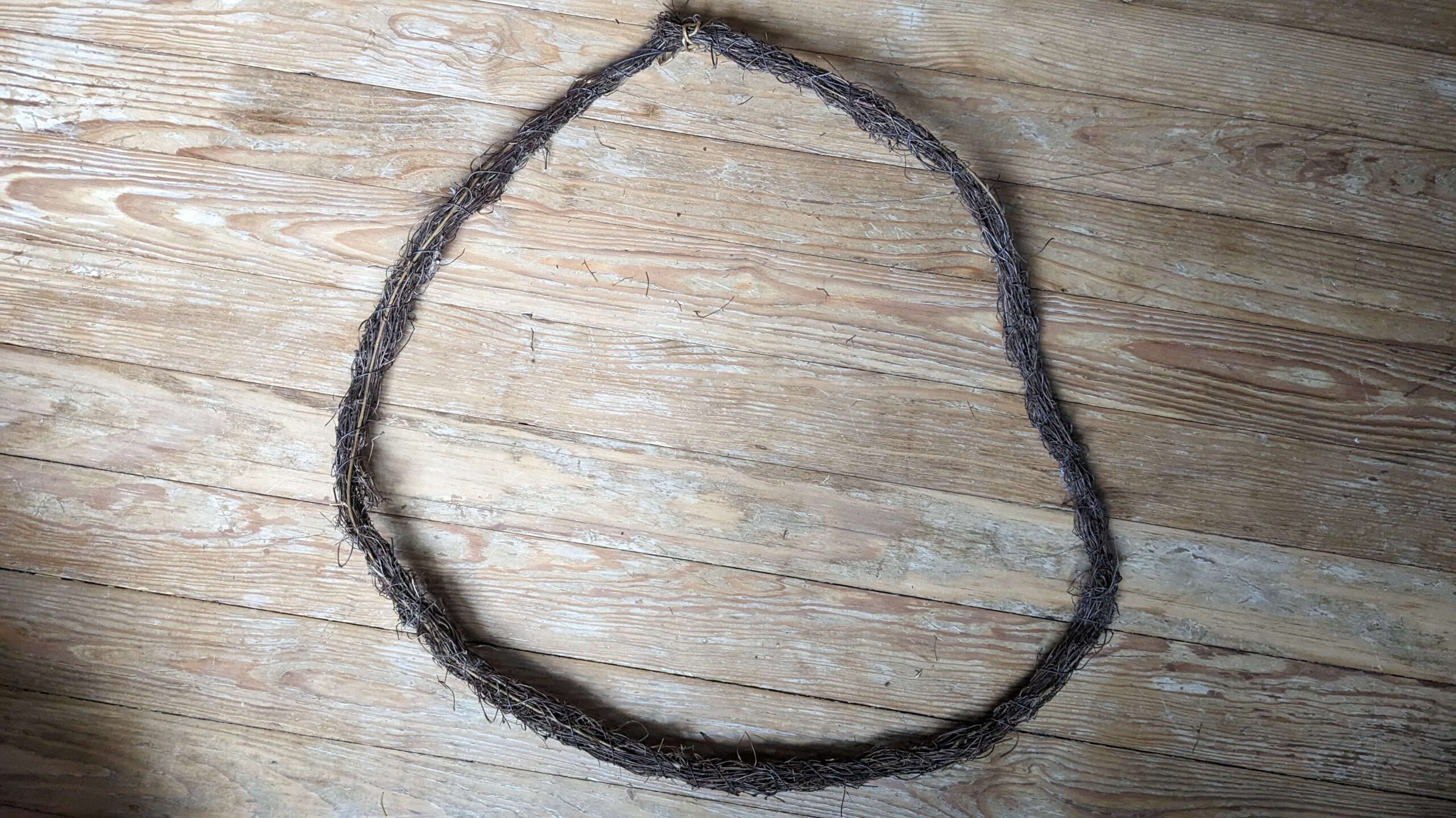 large wreath made of a fake grape vine on a wooden floor