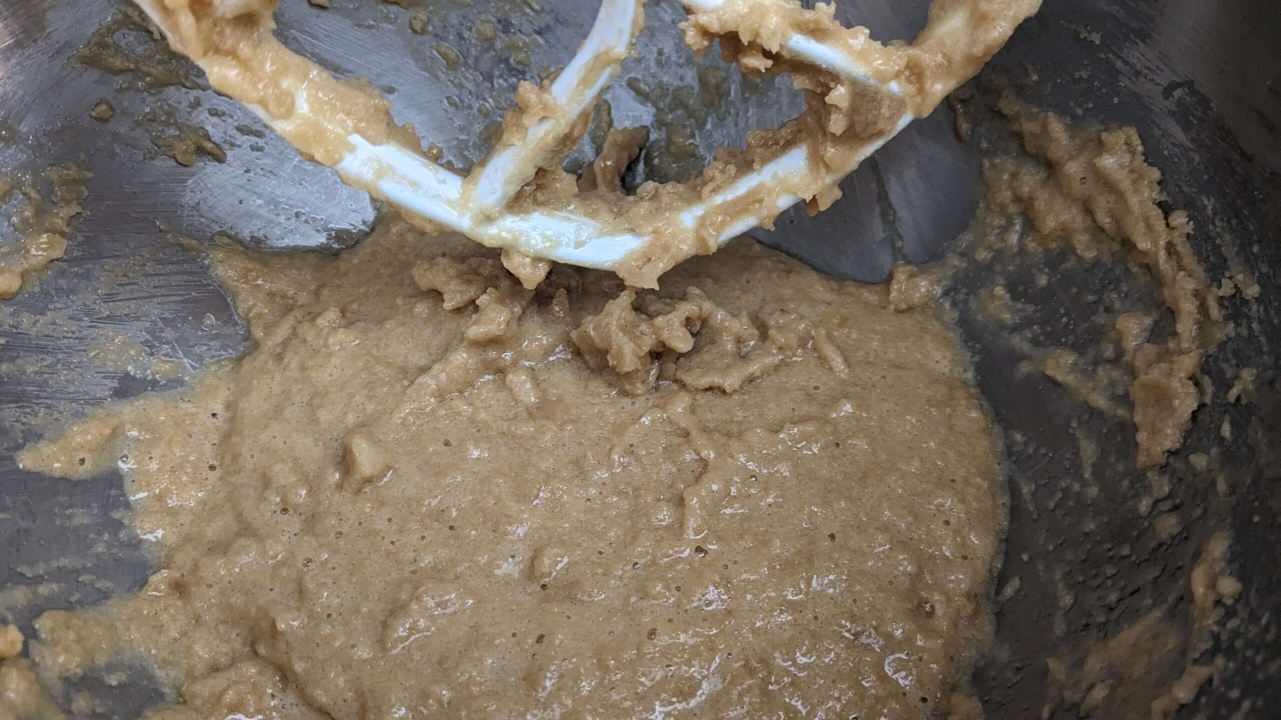 a light brown liquid batter in a kitchen aid mixer