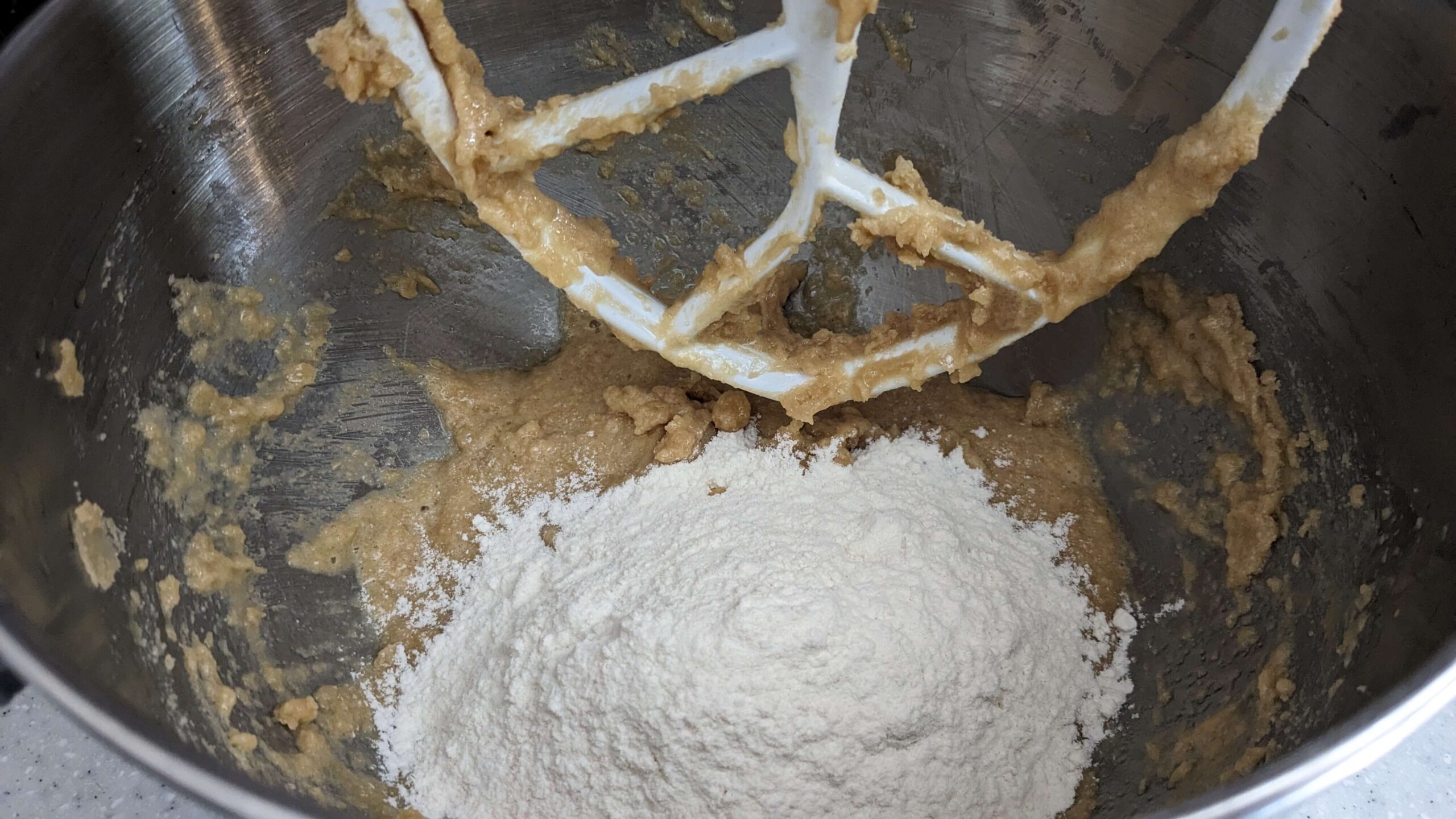 flour on top of light brown batter in a kitchen aid mixer