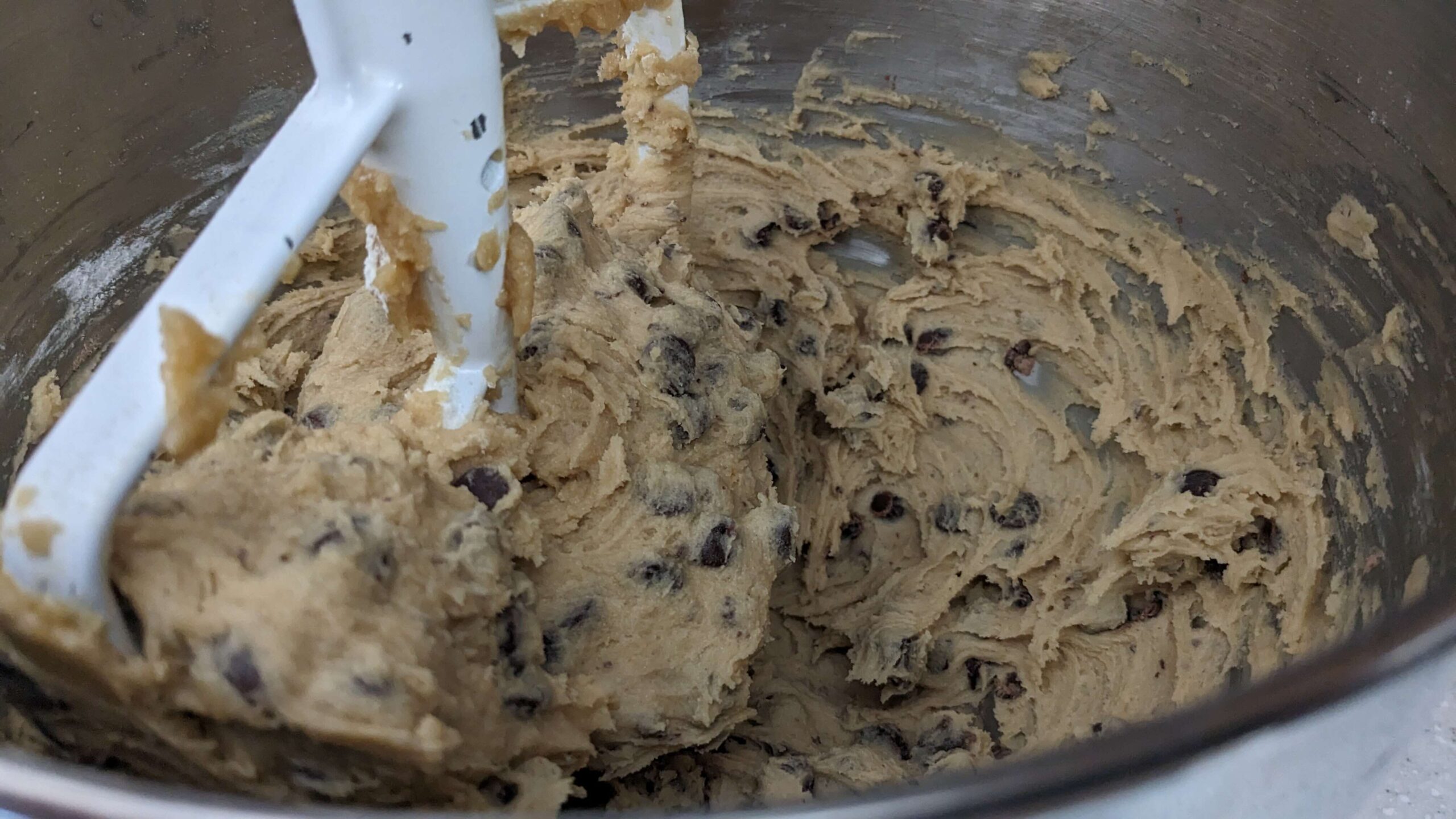 a kitchen aid mixer beating chocolate chips into dough