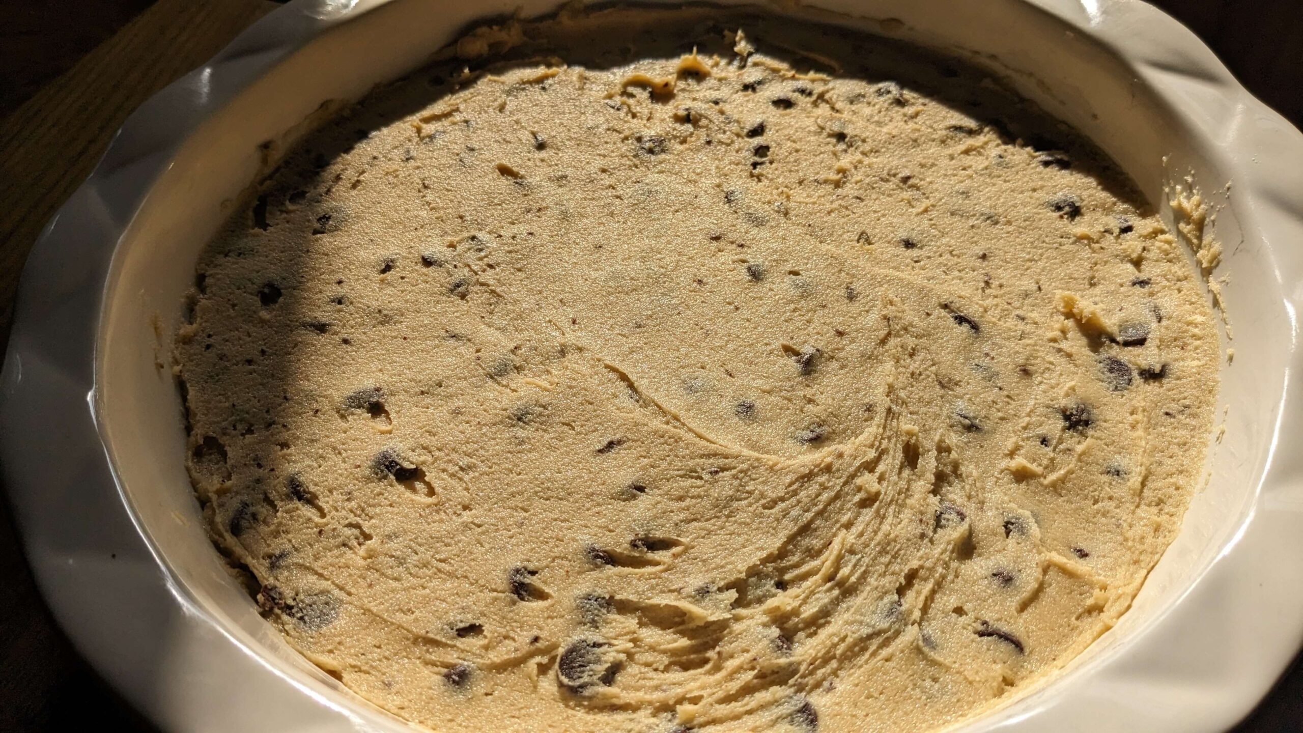 chocolate chip cookie dough smoothed into a pie plate 