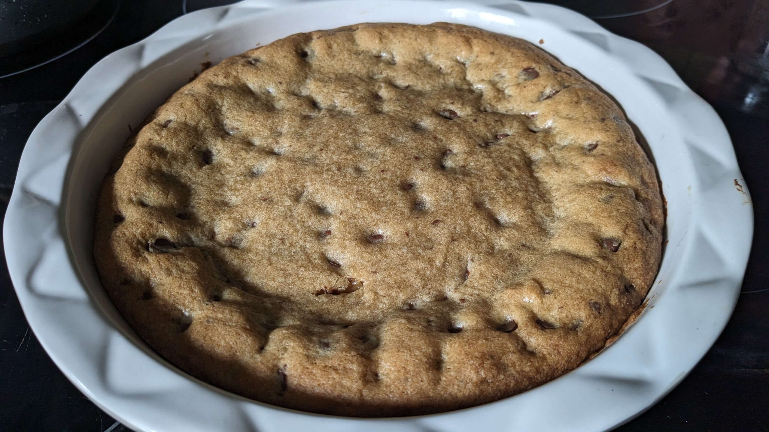 a pie plate holding chocolate chip cookie pie