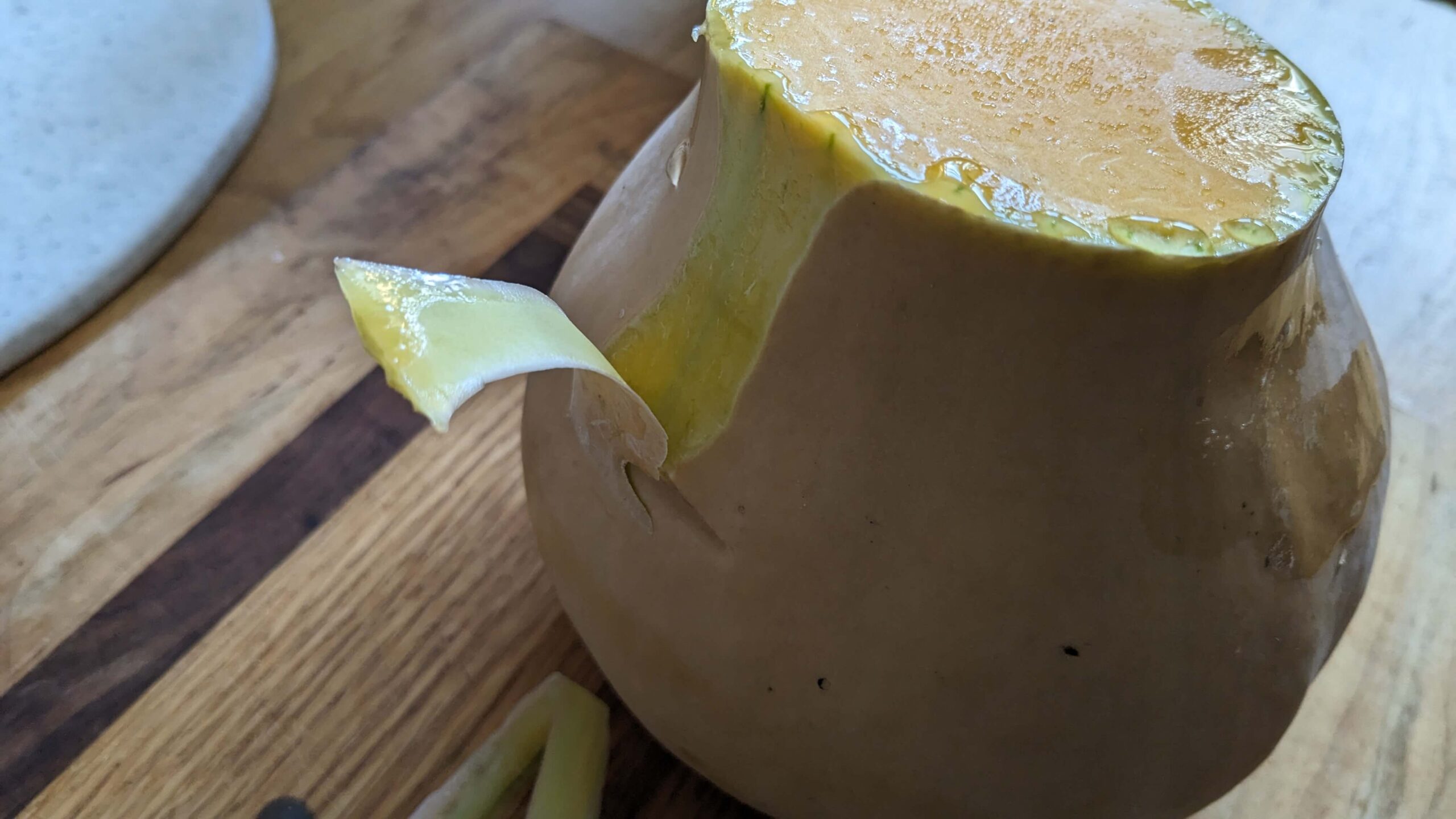 half of a butternut squash with one section peeled