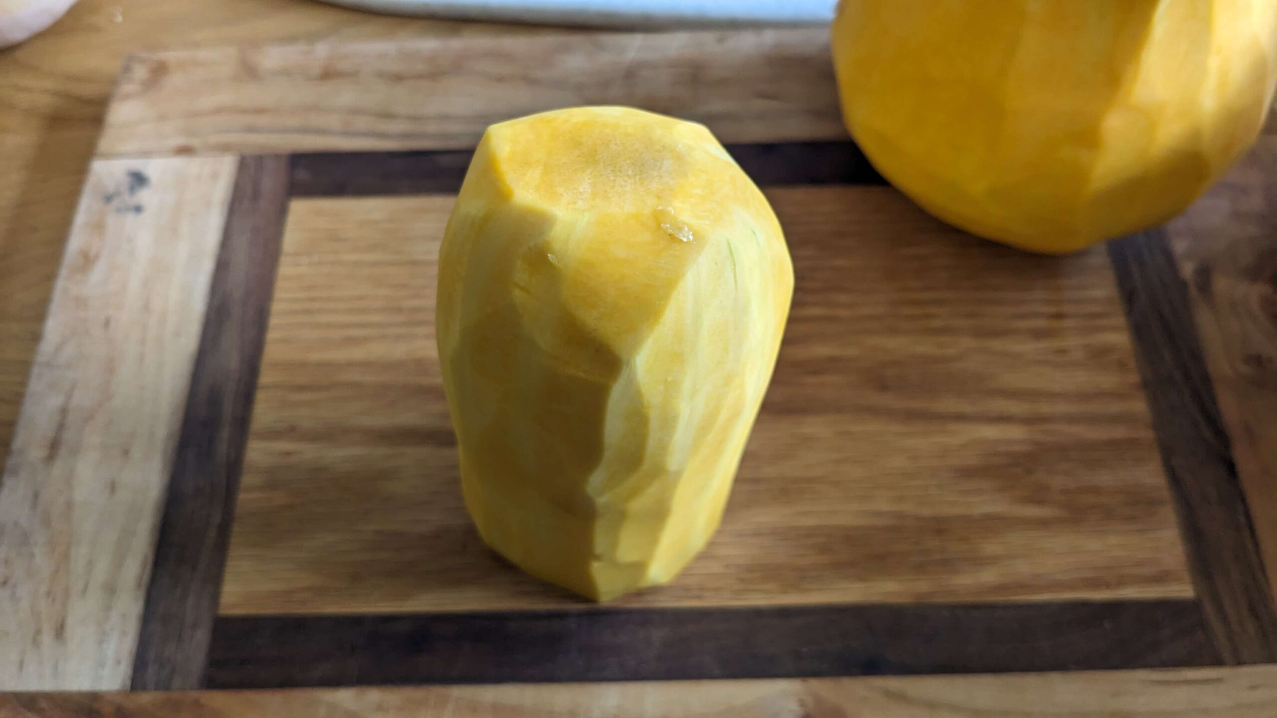 peeled butternut squash on a cutting board