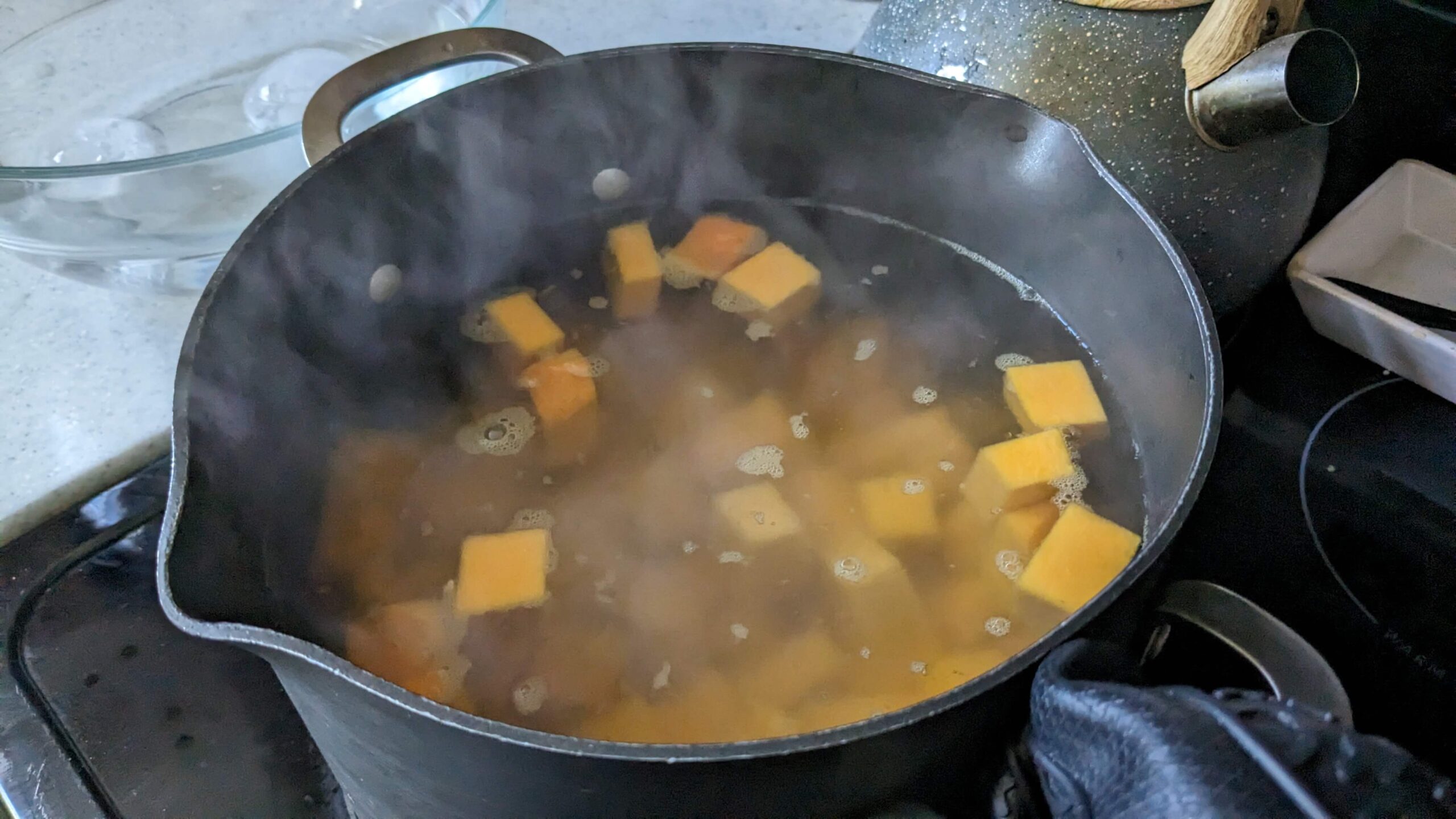 butternut squash in a pot of heated water on the stove 