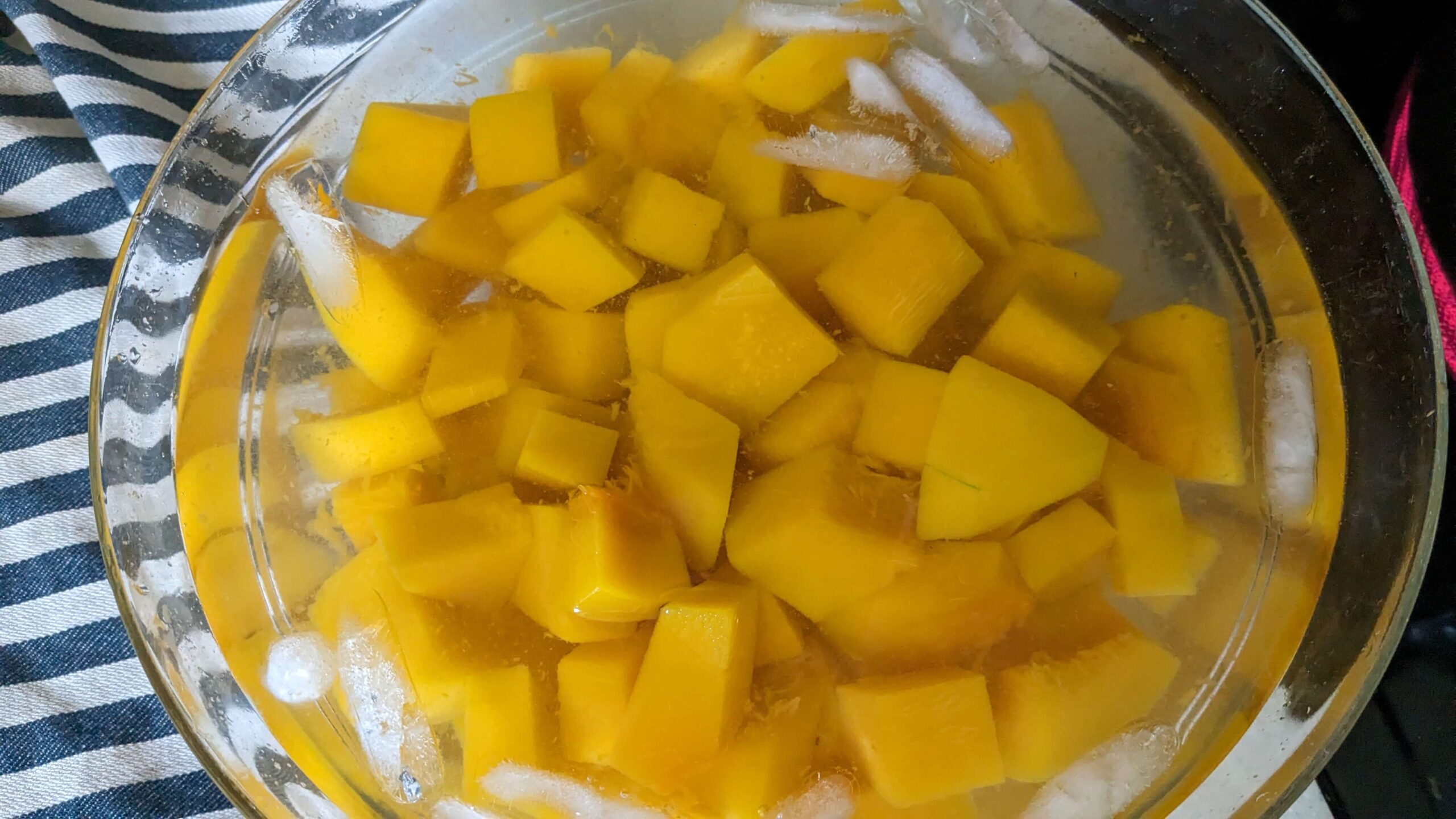 diced butternut squash in a bowl of ice water
