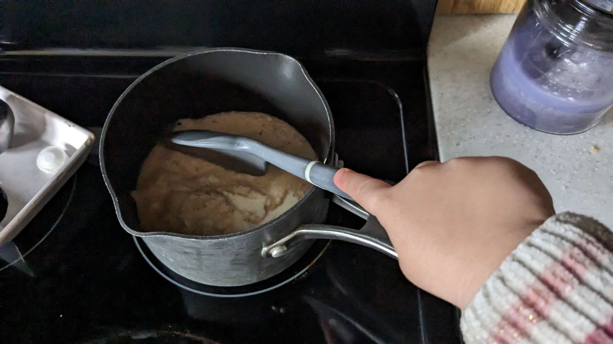 toddler stirring a pot on the stove