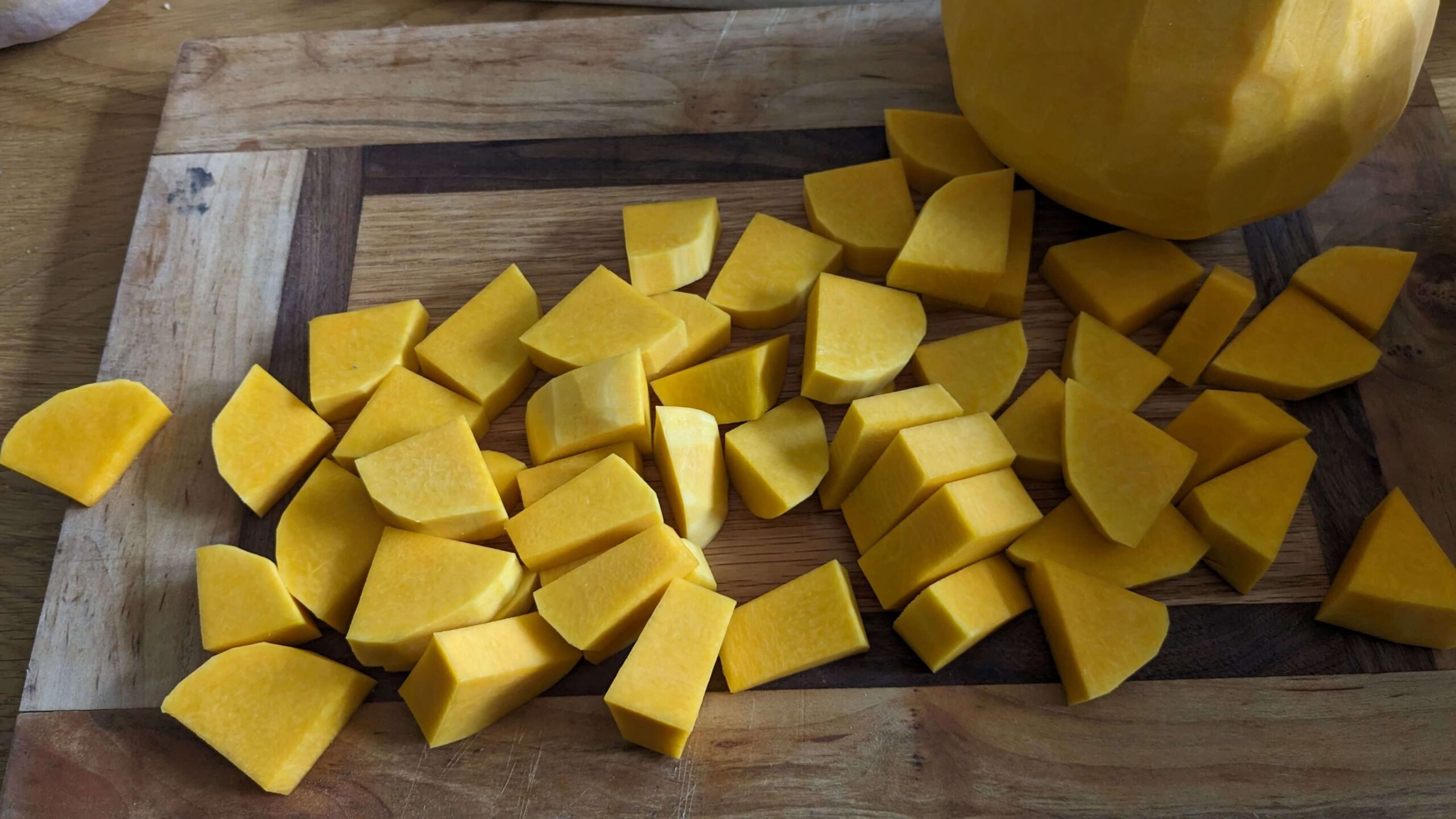 pile of cubed pieces of butternut squash on a cutting board