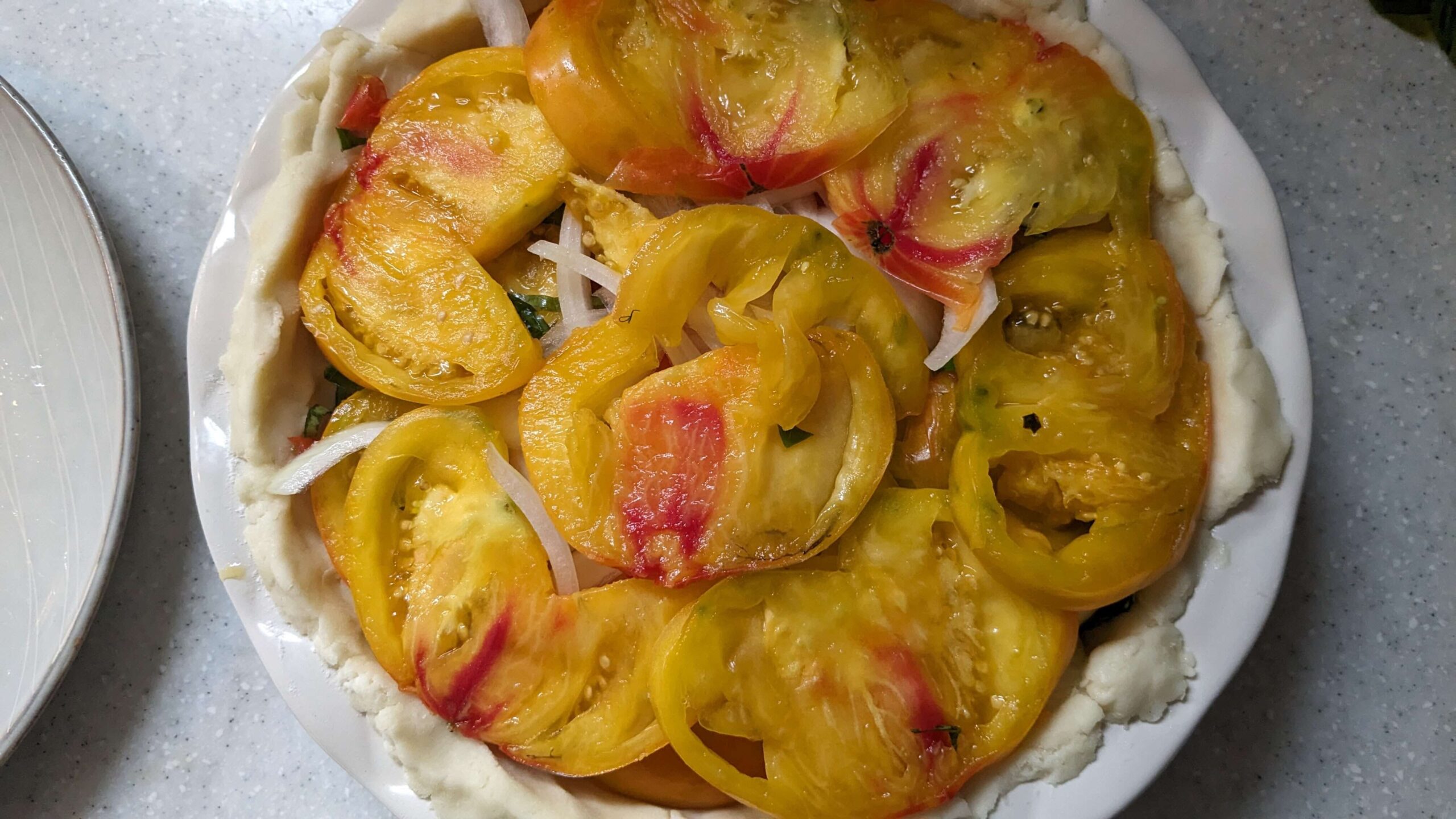slices of red and yellow marbled tomatoes in a pie plate