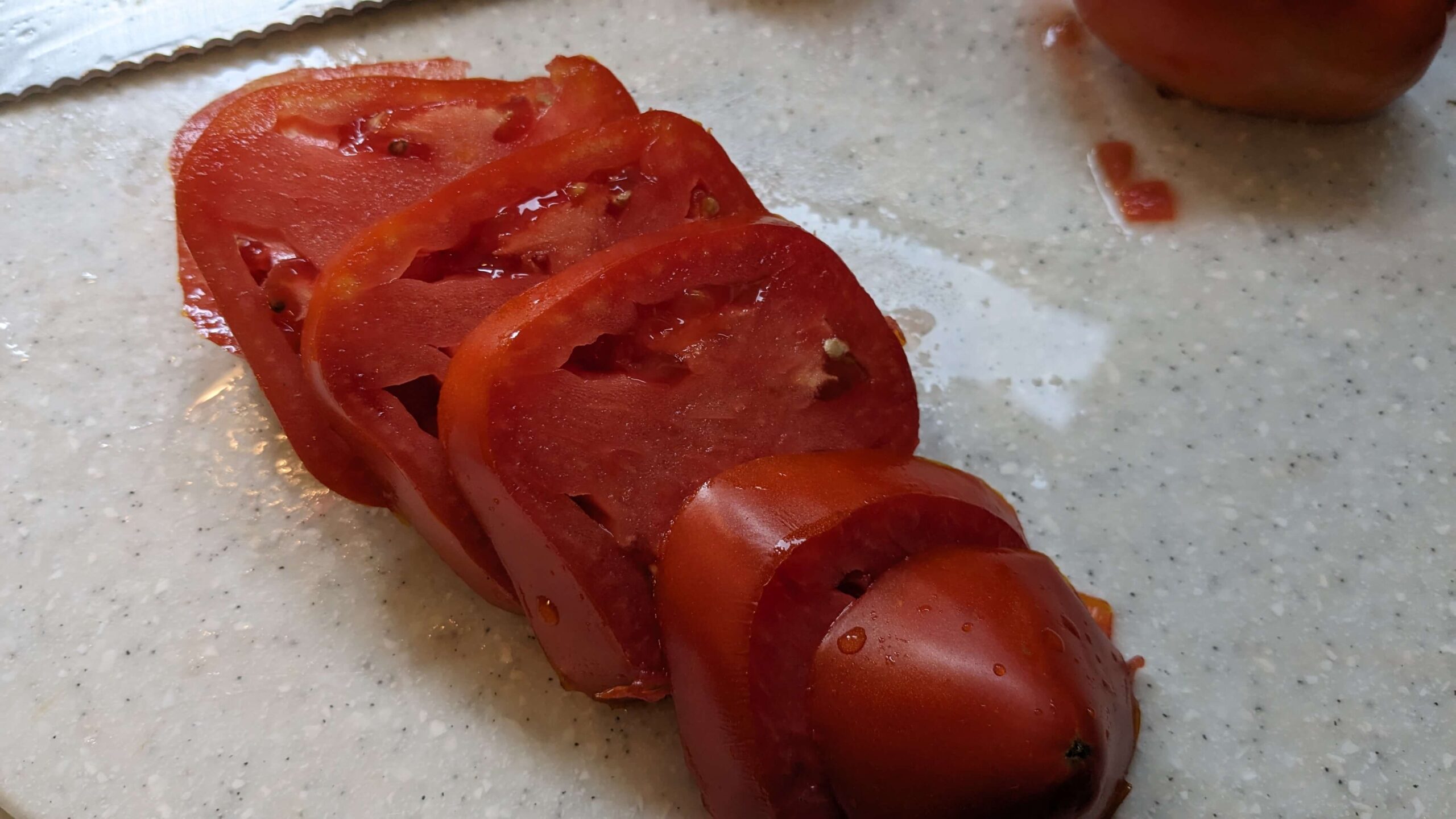 sliced amish paste tomato on a cutting board