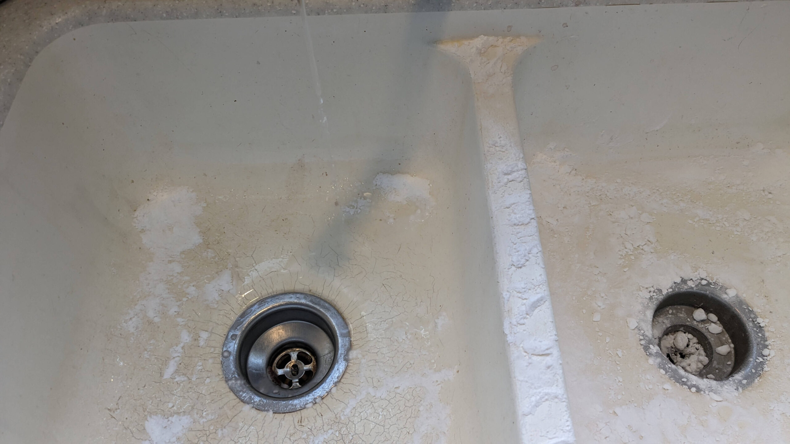 water dripping into a sink that has baking powder spread out over it