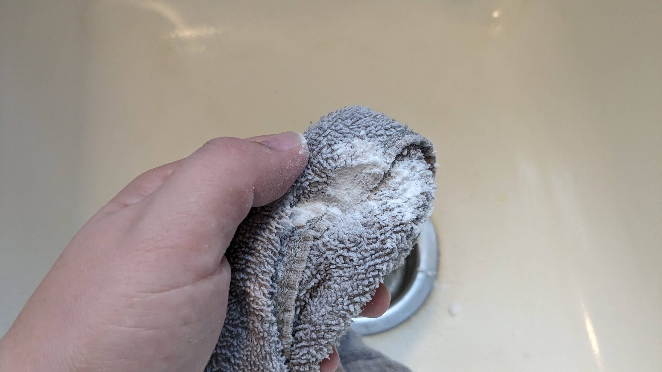 woman holding a washcloth with baking powder on it 