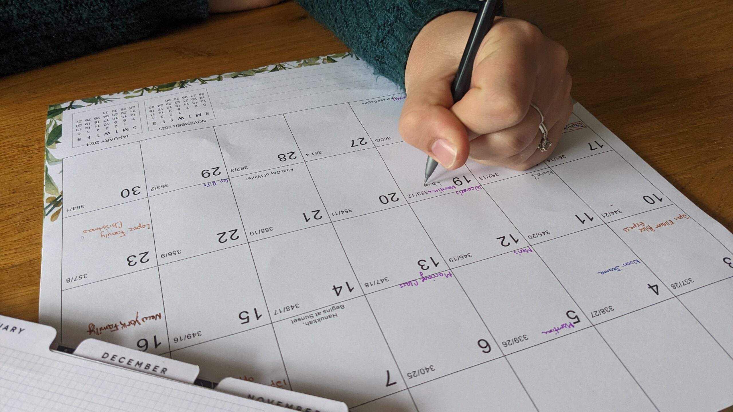 woman writing on a wall calendar