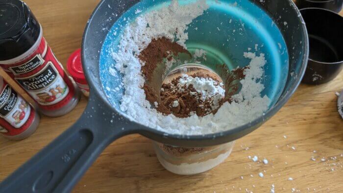 powdered sugar and cocoa powder in a funnel