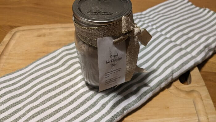 a mason jar with a ribbon and tag around it that says spiced hot chocolate mix