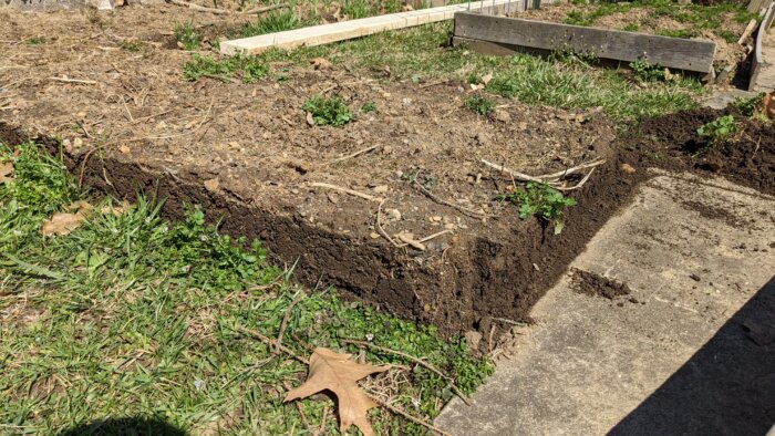 Square pile of soil formed by a raised bed that was removed.