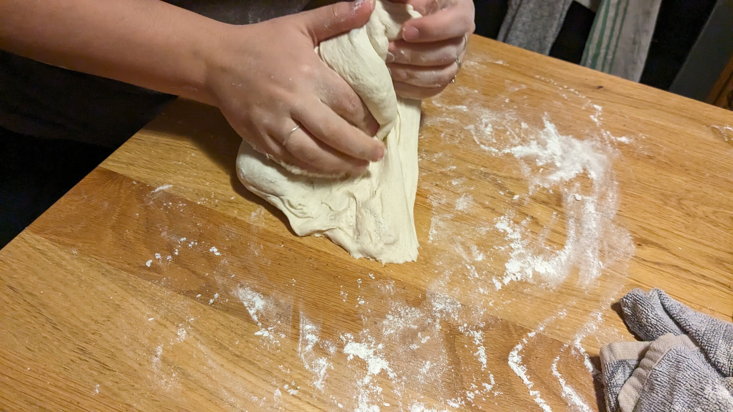 woman beginning to form sourdough into a loaf
