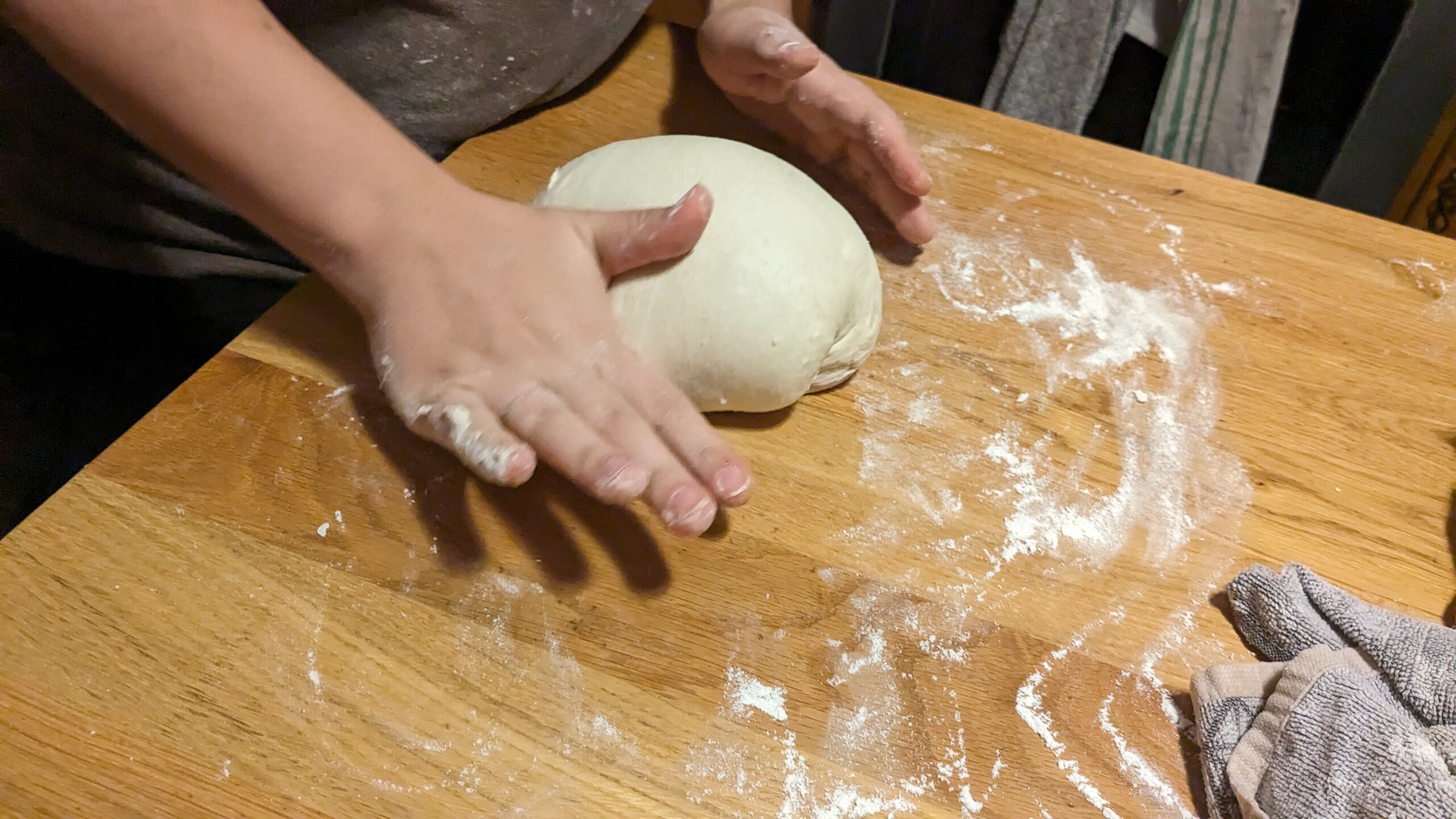woman pulling and pushing a sourdough loaf