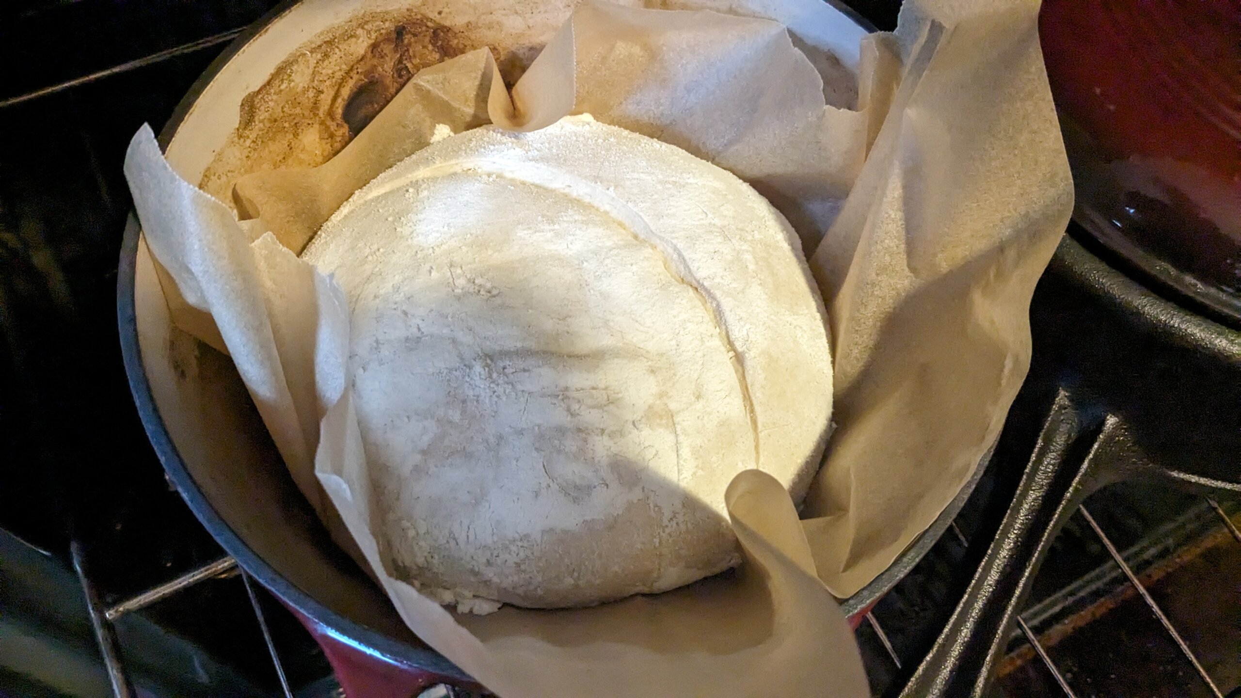 sourdough bread dough on parchment paper in a dutch oven