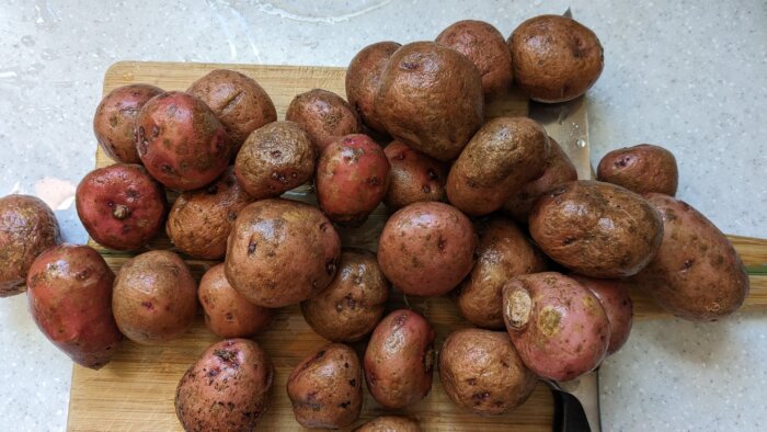 a pile of baby potatoes on a cutting board