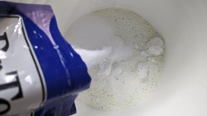Epsom salts pouring into a bucket of powder