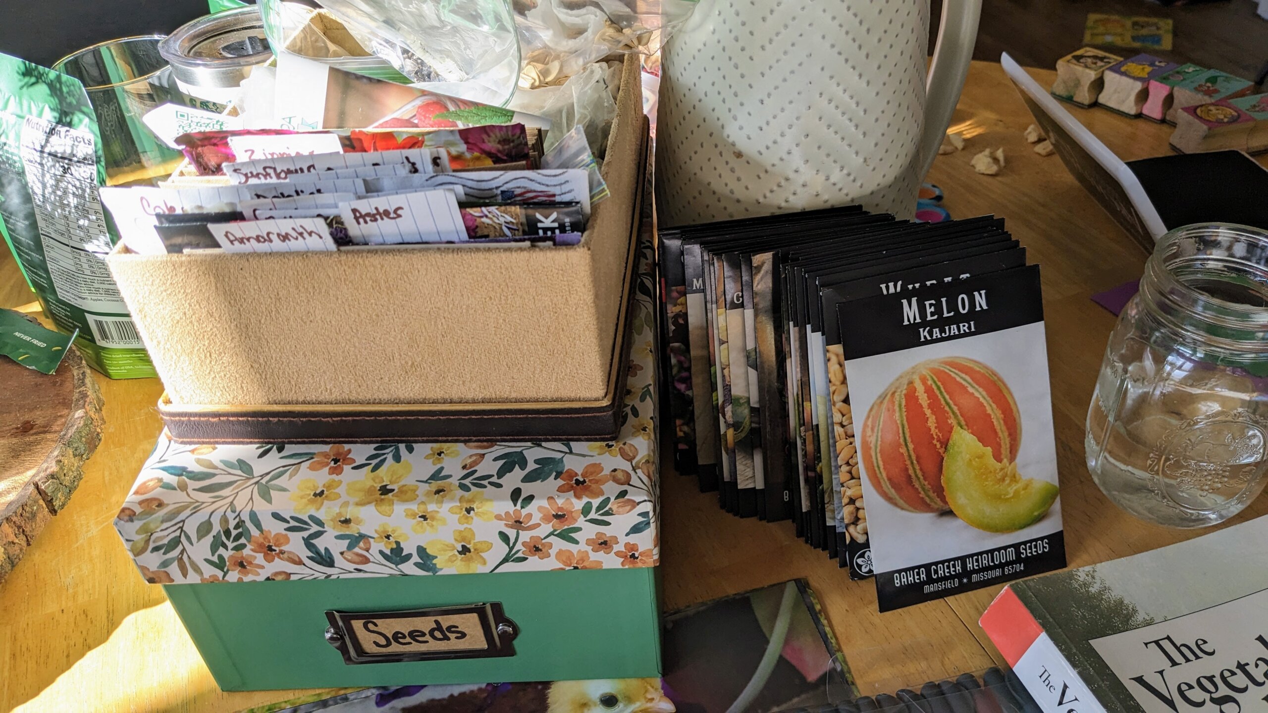 boxes of seeds next to a pile of seed packets