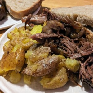 chinese pot roast on a plate with smashed potatoes and sliced sourdough bread