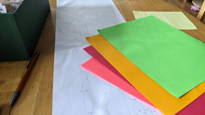 four sheets of colored papers on a to scale drawing of a garden