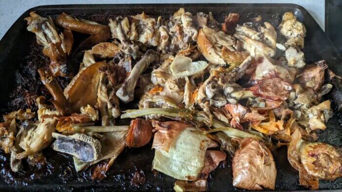 chicken bones and vegetables scraps on a tray