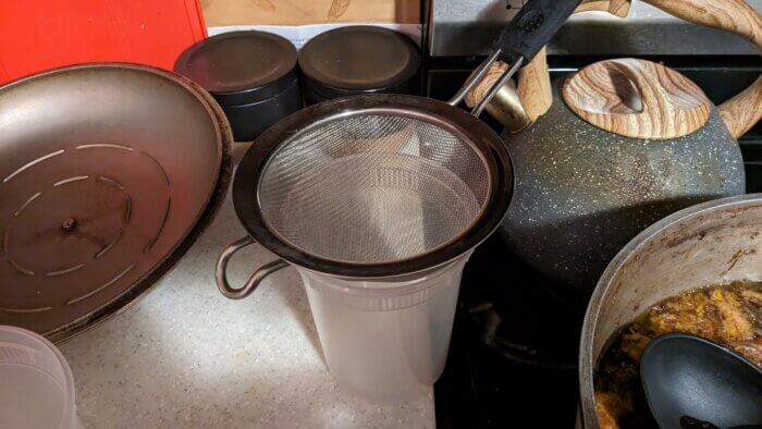 a strainer on a plastic container