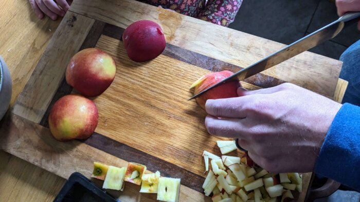 man cutting apples on a cutting board
