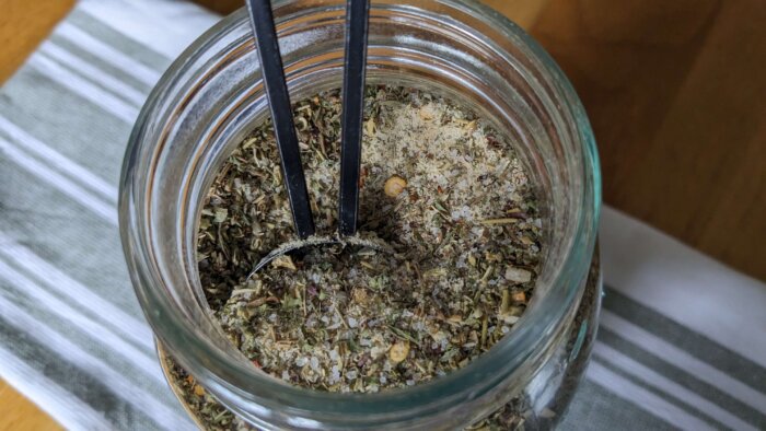 Homemade Bulk Italian Dressing Mix in a mason jar with a tablespoon measument