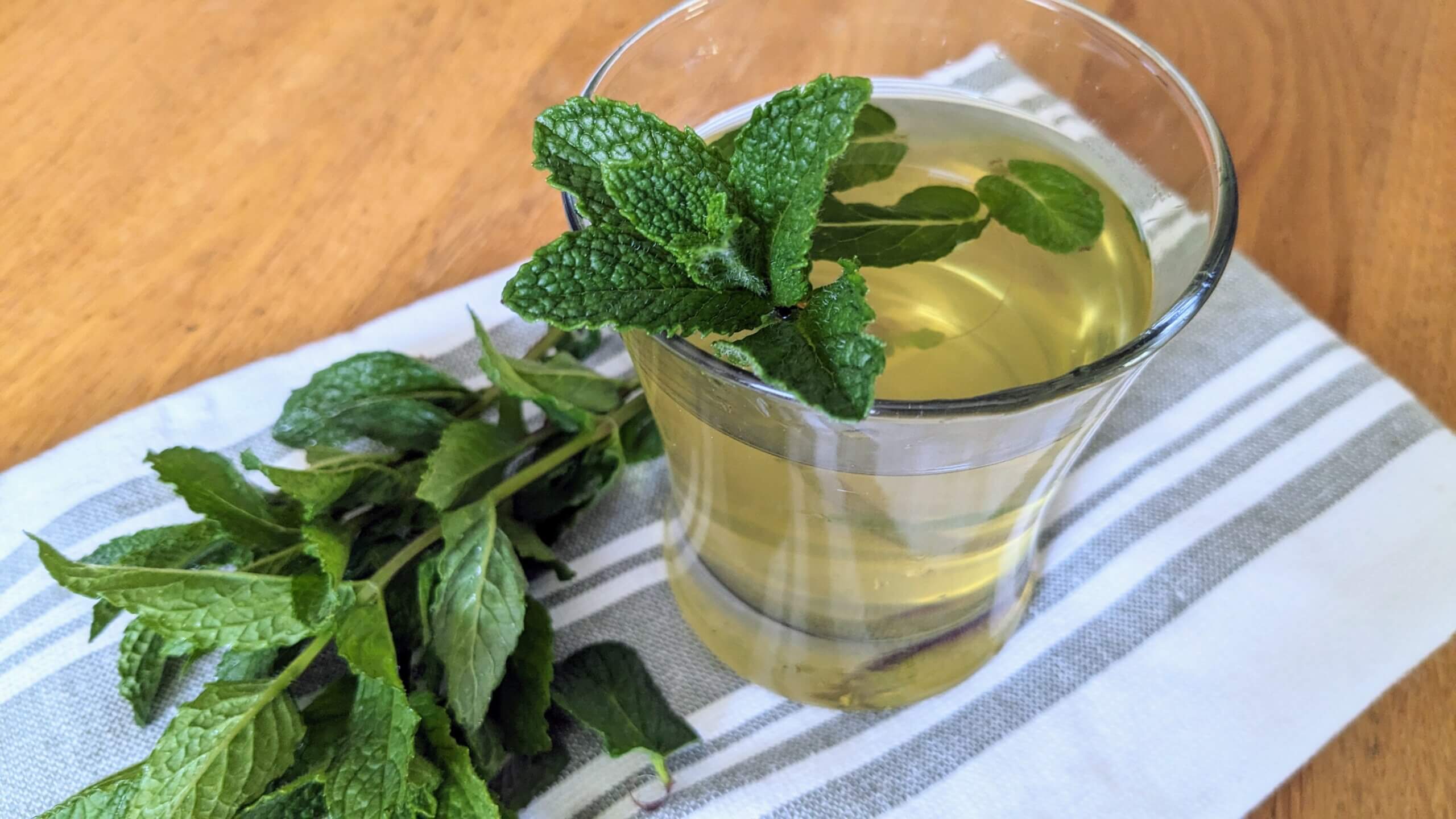 Fresh Iced Mint Tea with mint sprigs next to it