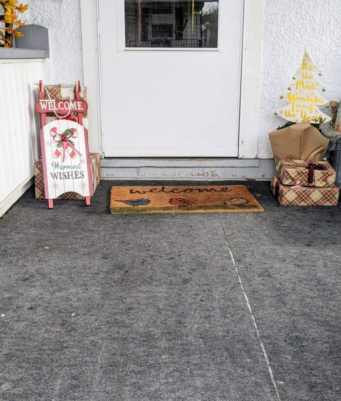 wrapped presents and Christmas decorations on a front porch