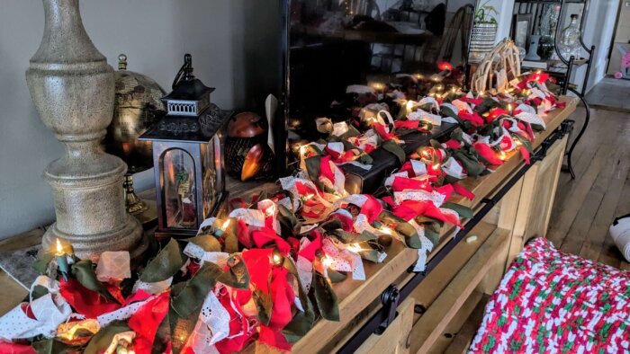 lighted rag tie garland on a console table in Christmas colors